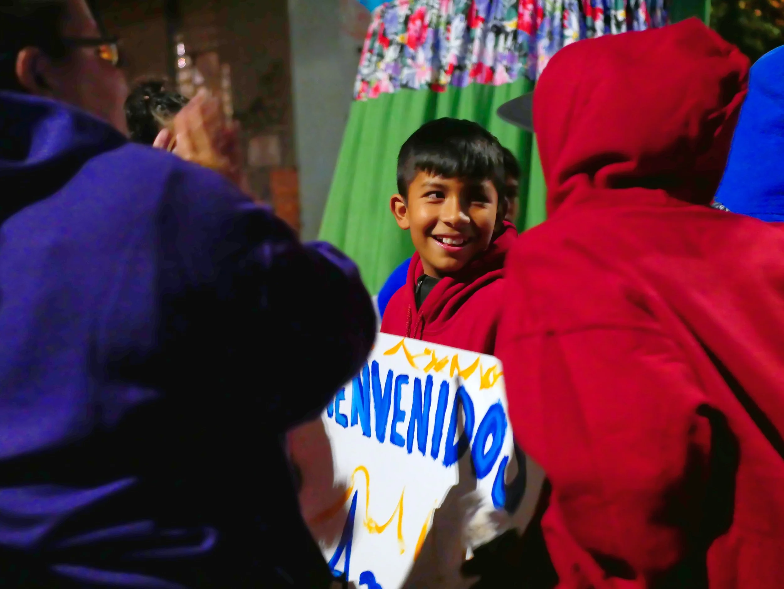 student smiles with a sign