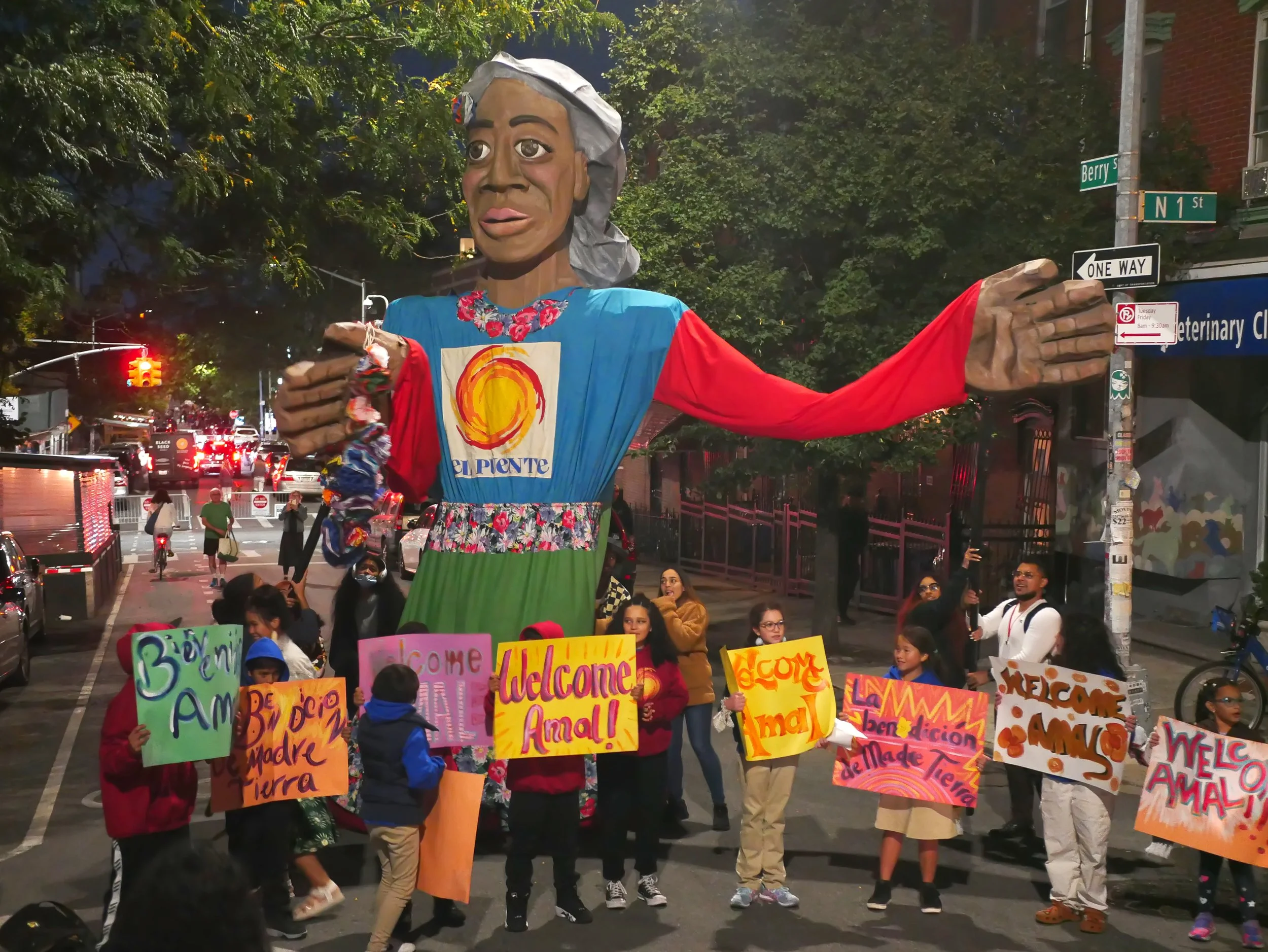 Wide view of students holding signs in front of a giant puppet