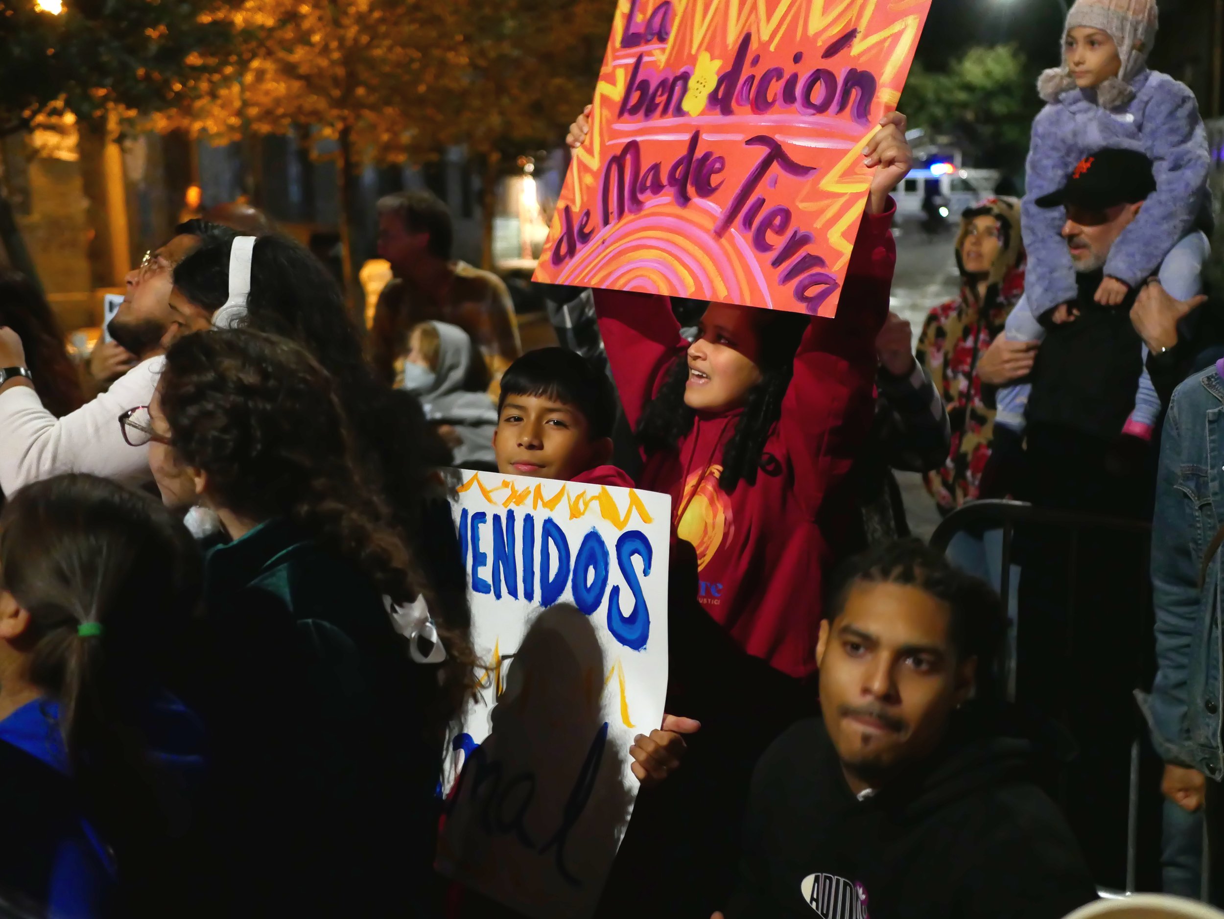 students hold signs greeting Amal