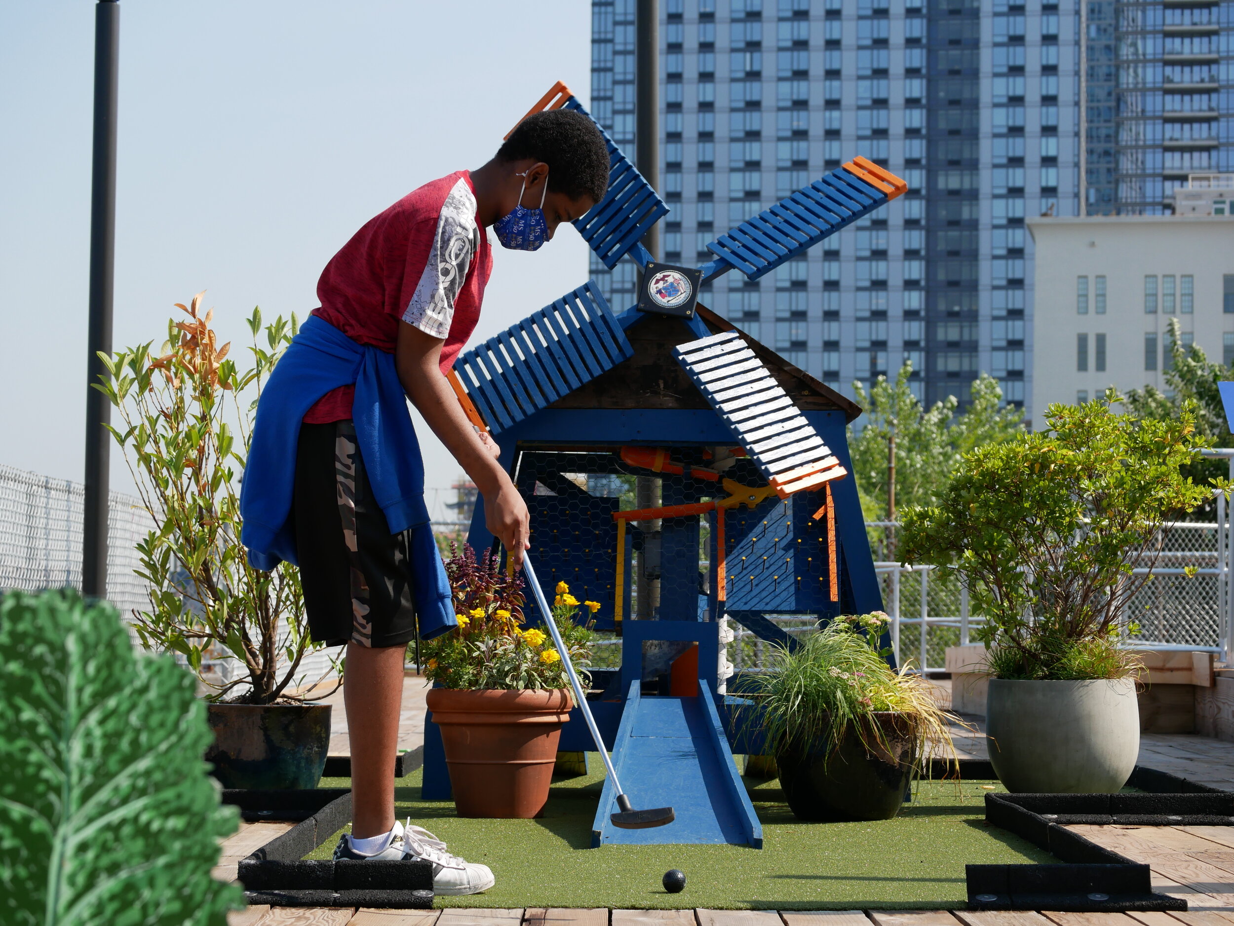 student plays mini golf
