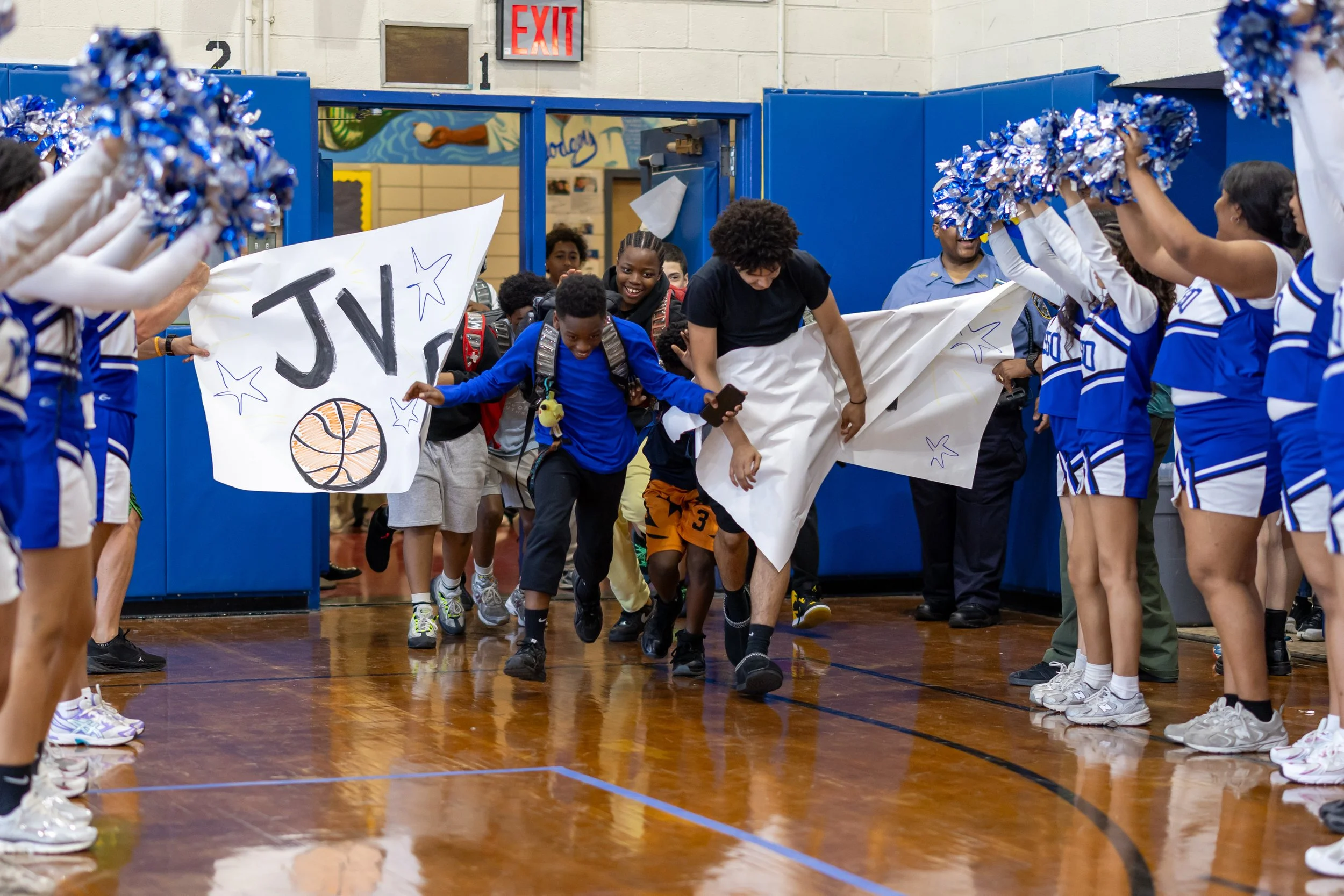 Students run through banners at pep rally