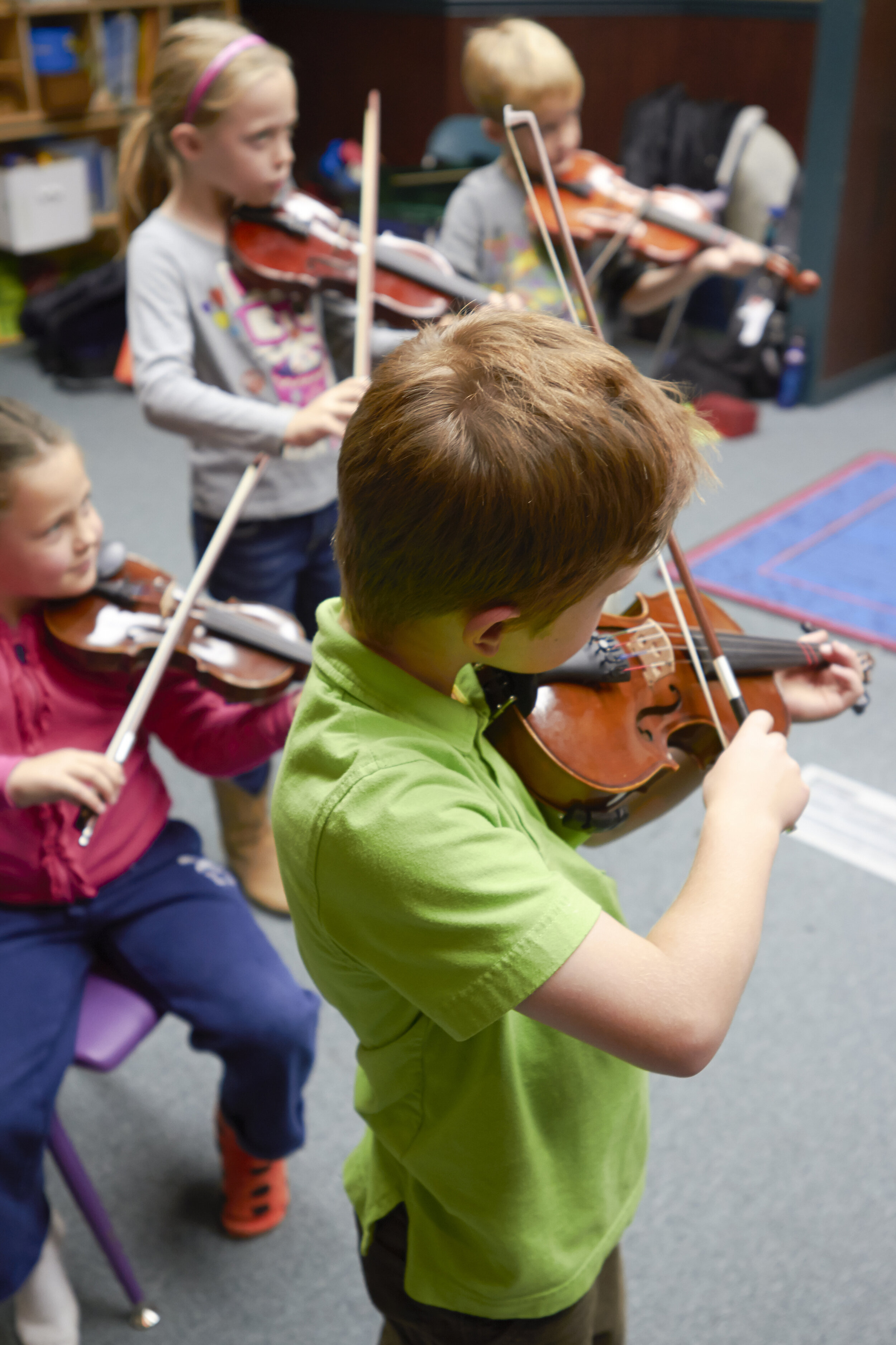 Students practice violin, recorder, and piano
