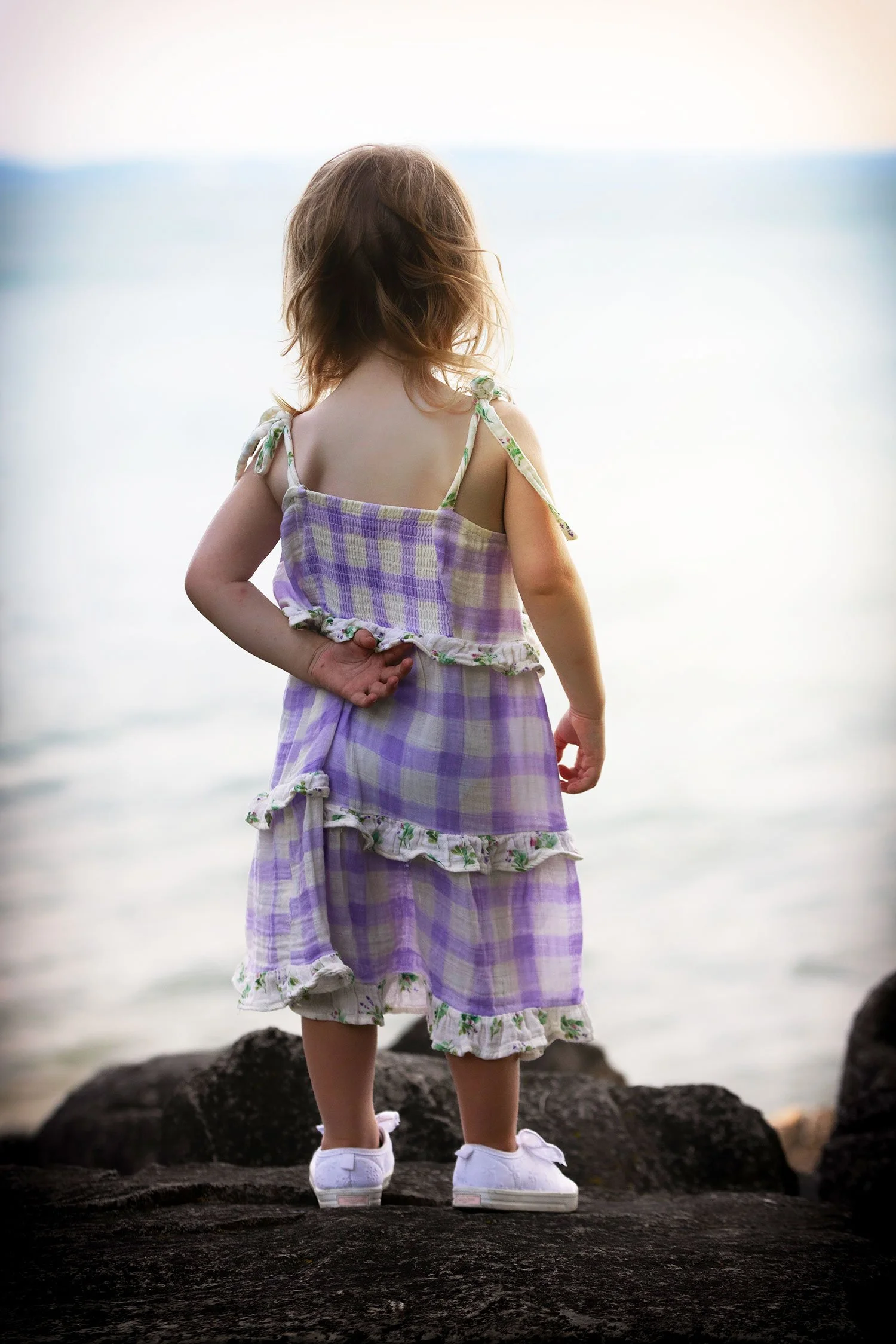 cute child stands on the rocks looking at Lake Erie at Lakeside, Ohio