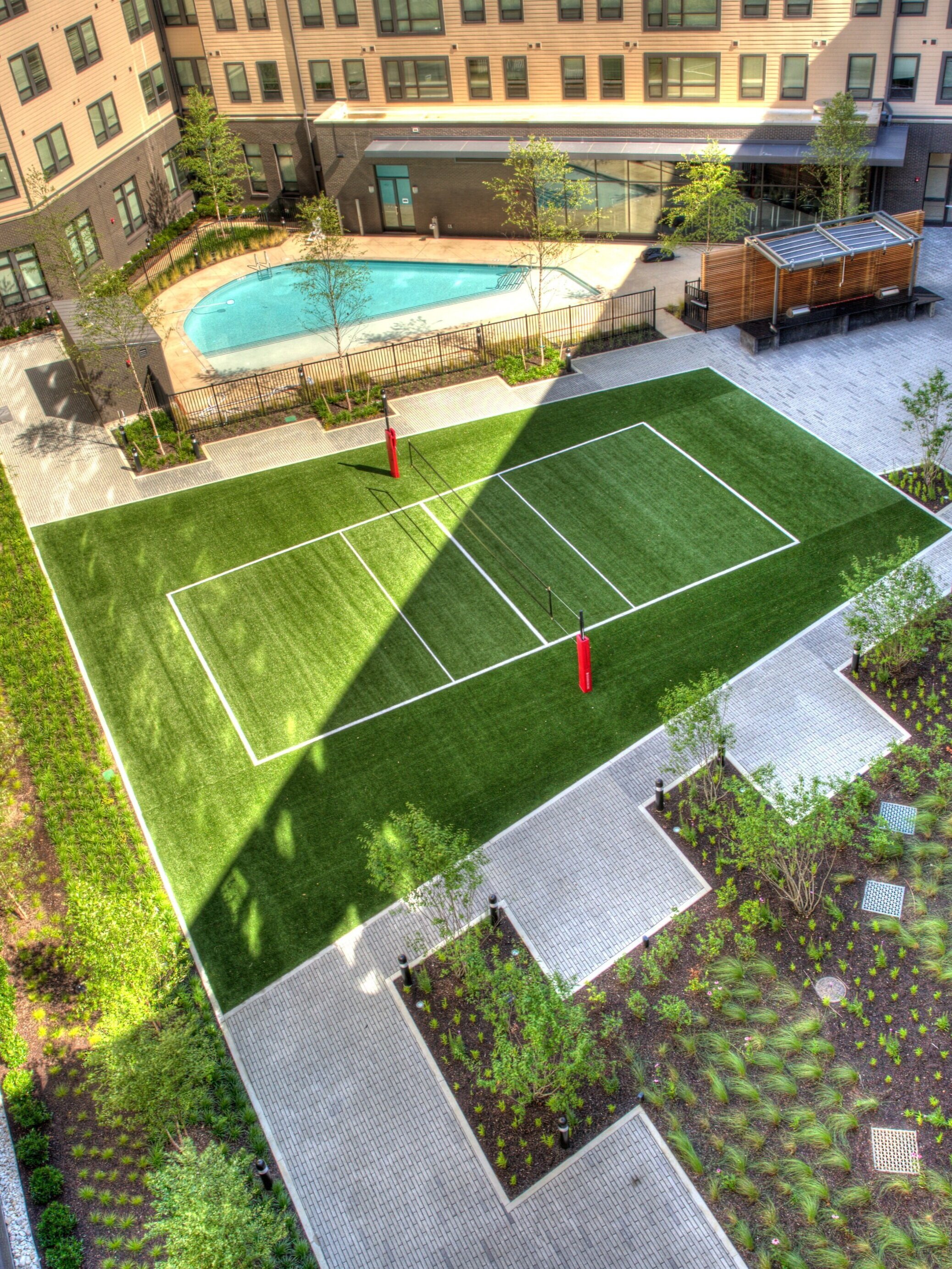   An aerial view of one of the amenity courtyards with view of the pool and volleyball court.  