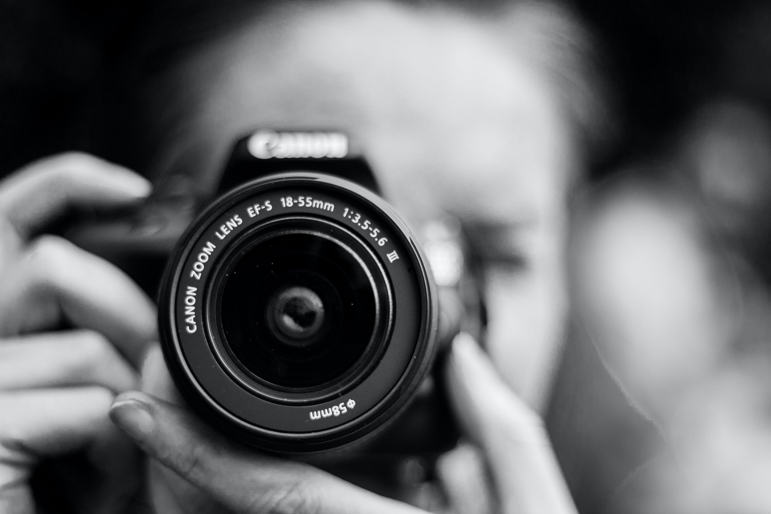 black and white photo of a wedding photographer aiming her camera