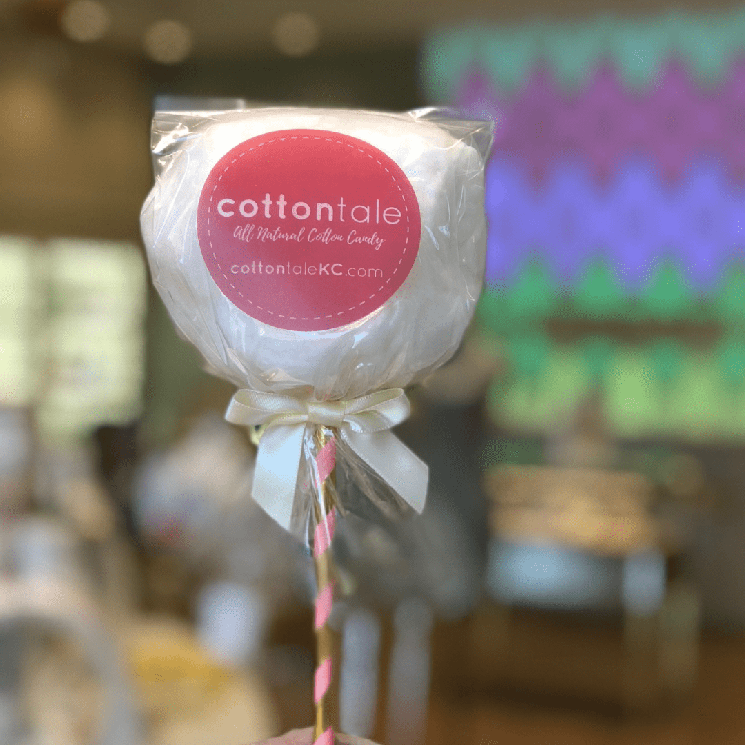 pale pink cotton candy lollipop with a label that reads "CottonTale All Natural Cotton Candy cottontaleKC.com"