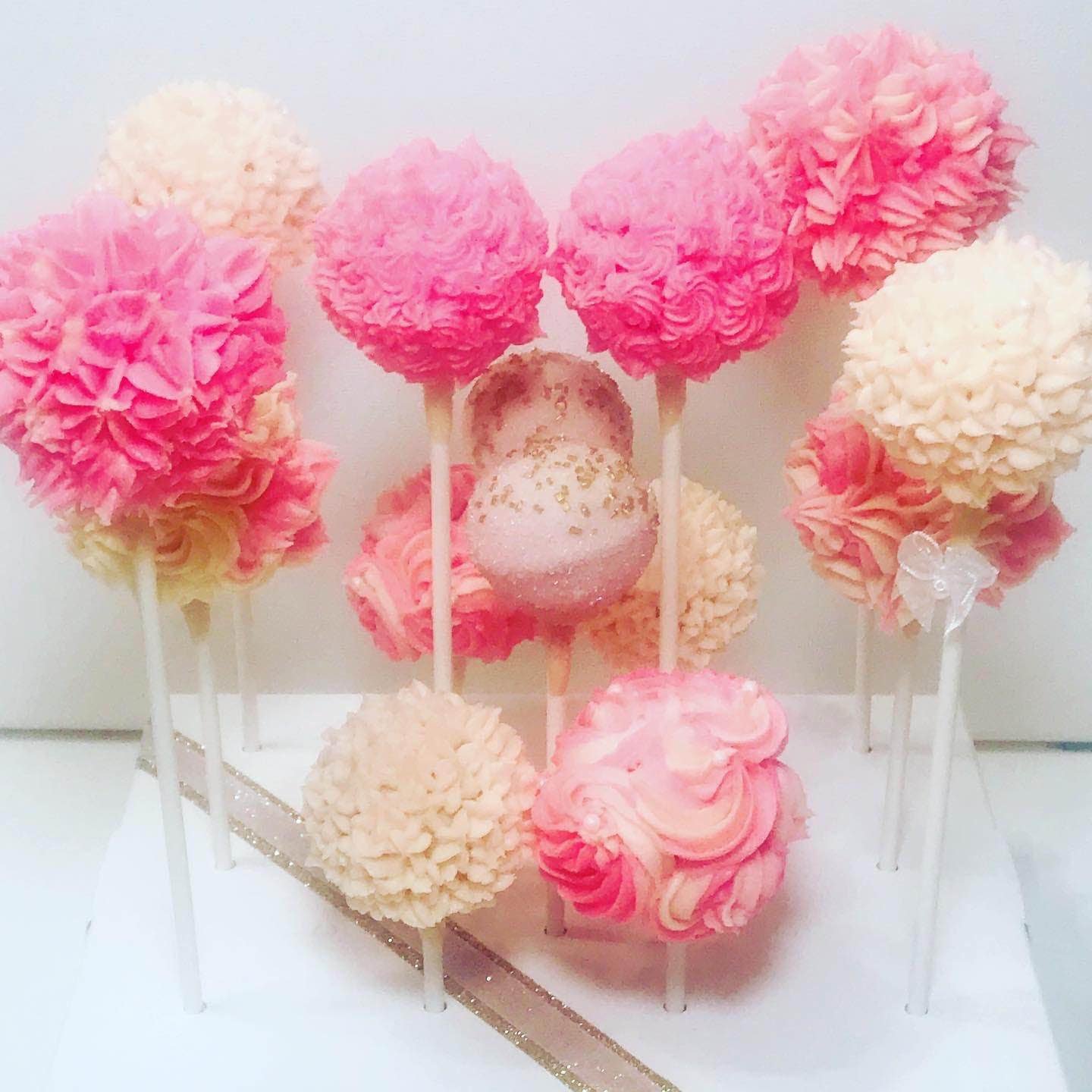 pink and white decorated cake pops from Cakepop Bakery