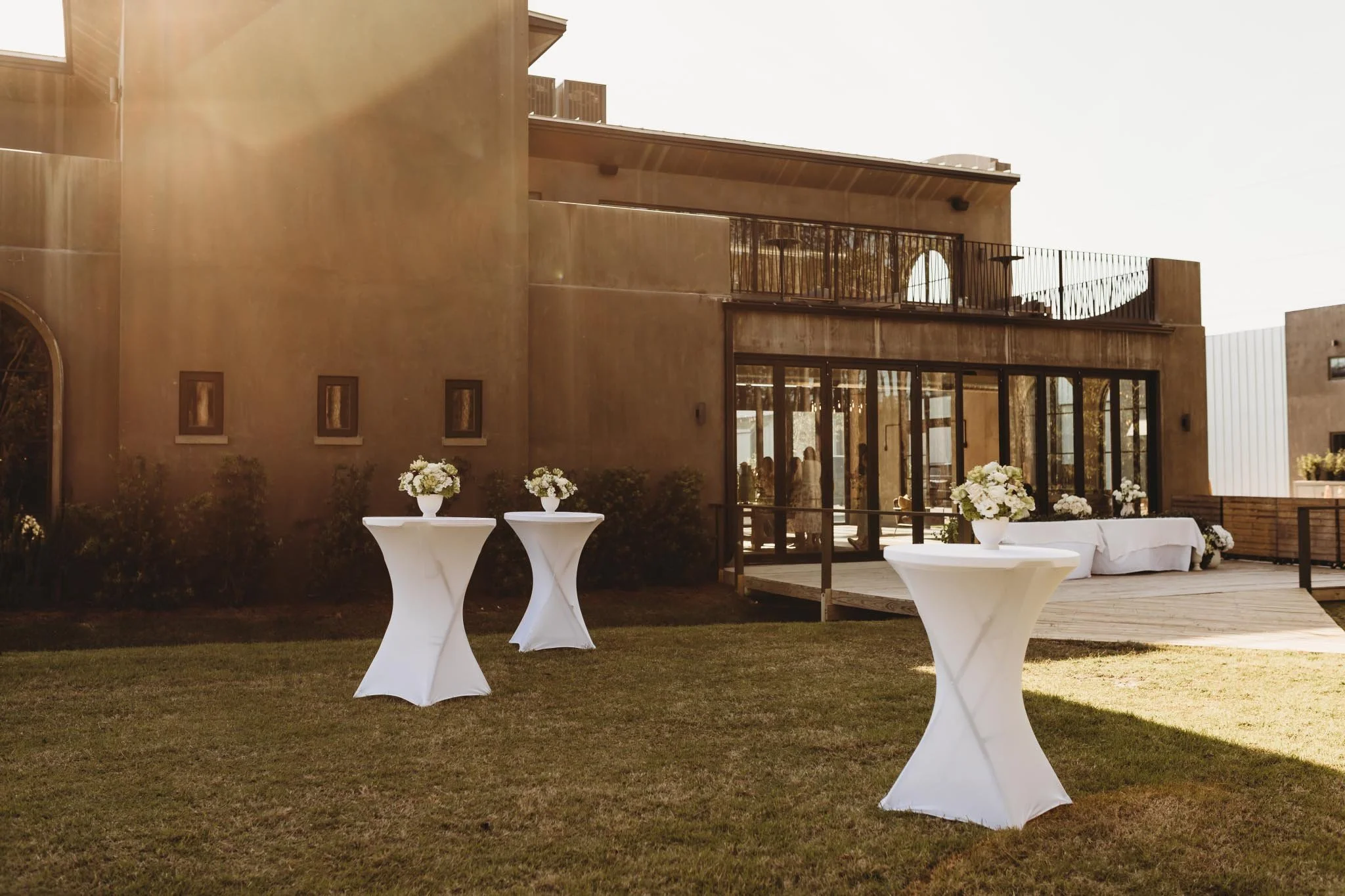 Cocktail hour setup outside of The Heritage House. The building is an Italian inspired concrete structure with a beautiful golden hour glow from the sun.