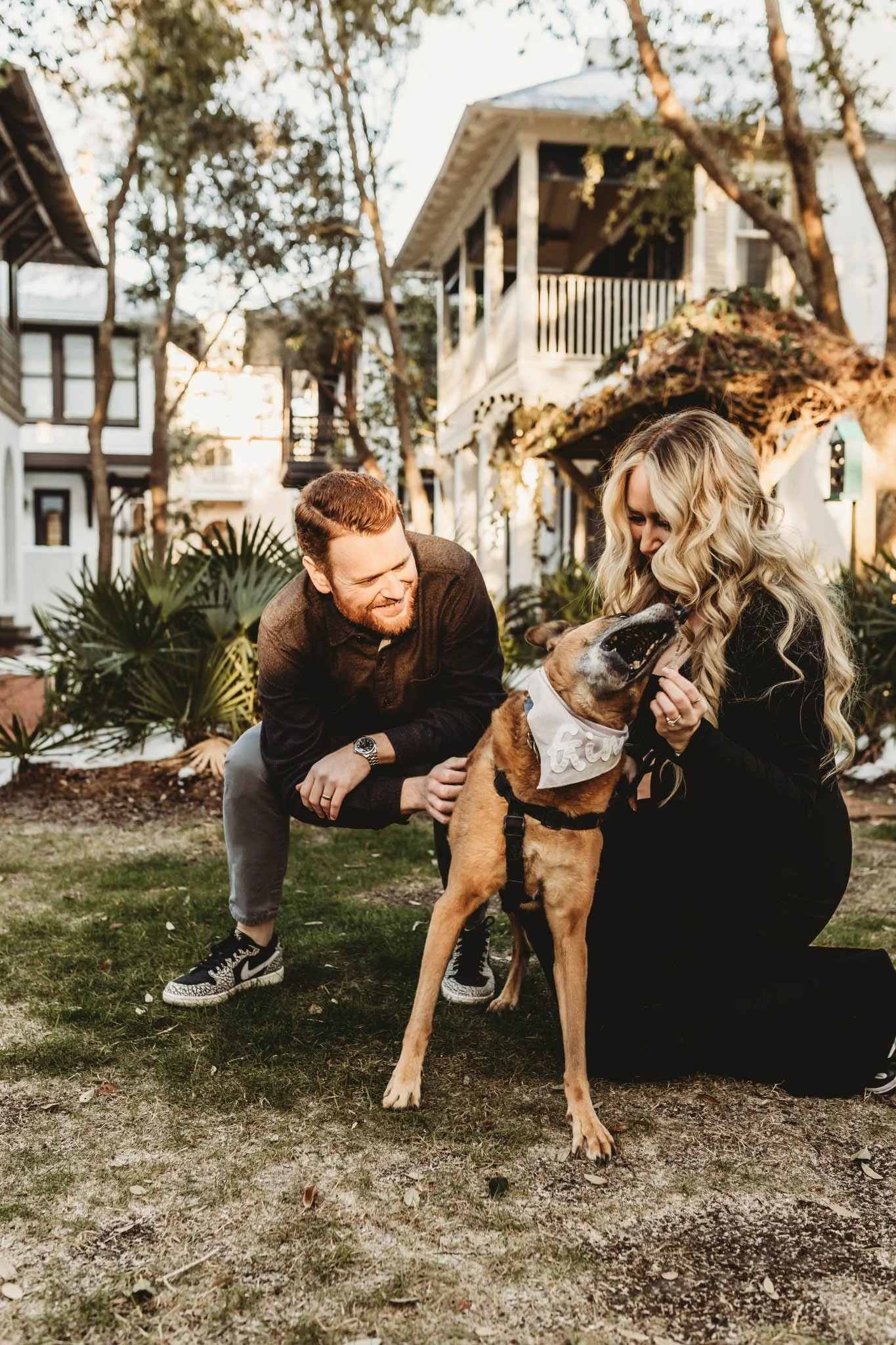Man and woman with their dog playing in a photoshoot at Alys Beach Florida