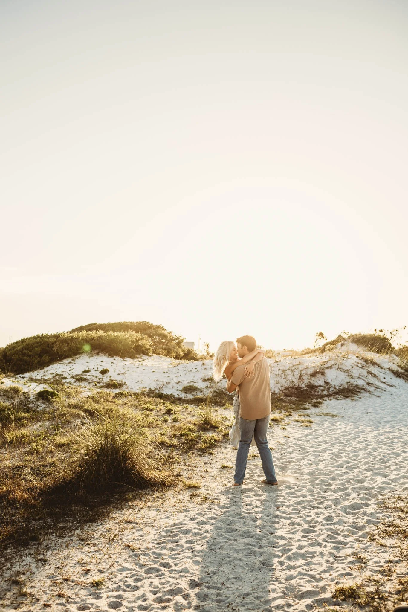 Couple holding each other on the beach at golden hour