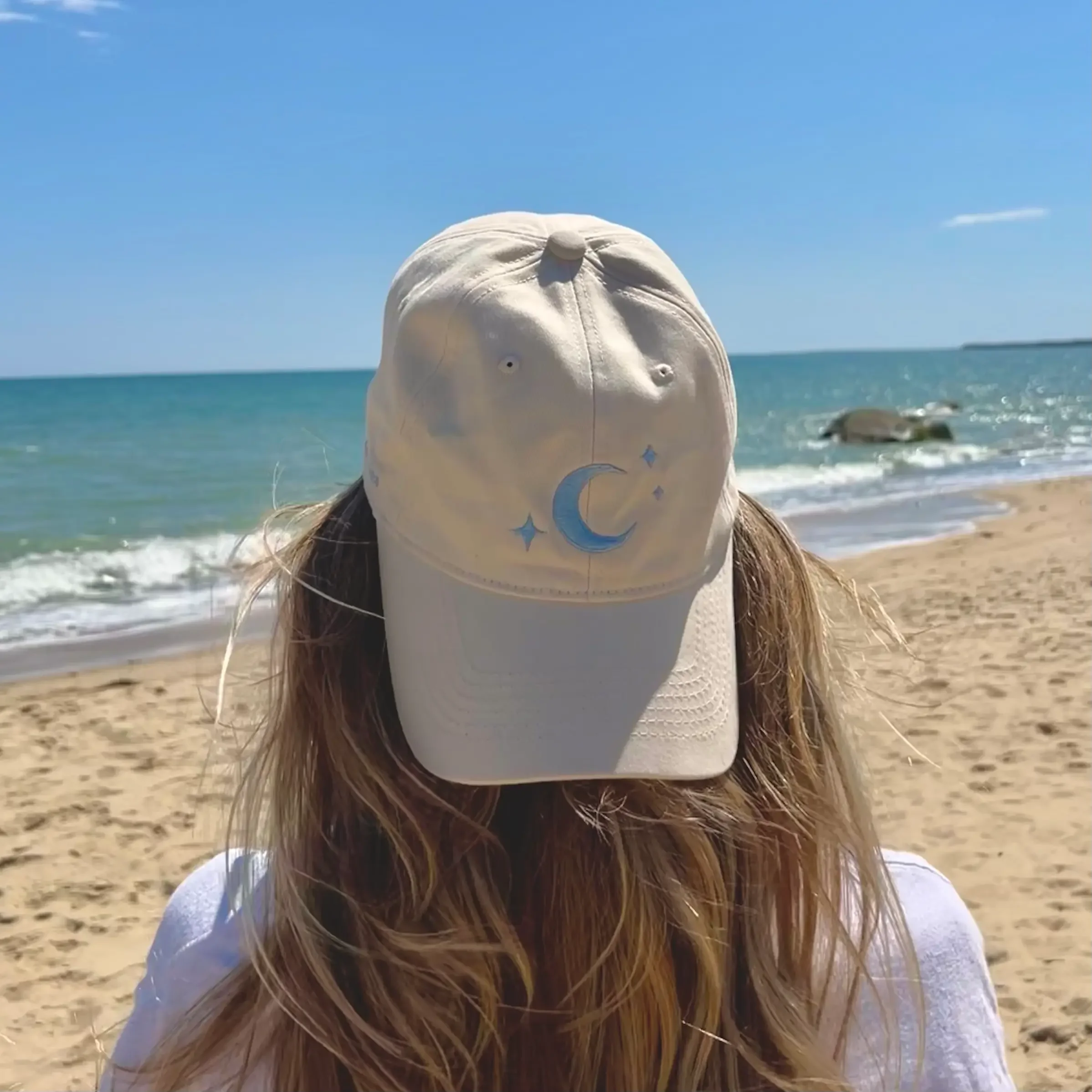 Atticus Poetry White pigment-dyed 100% brushed cotton dad hat with a centered moon embroidery and "CHASE YOUR STARS" stitched on the right.
