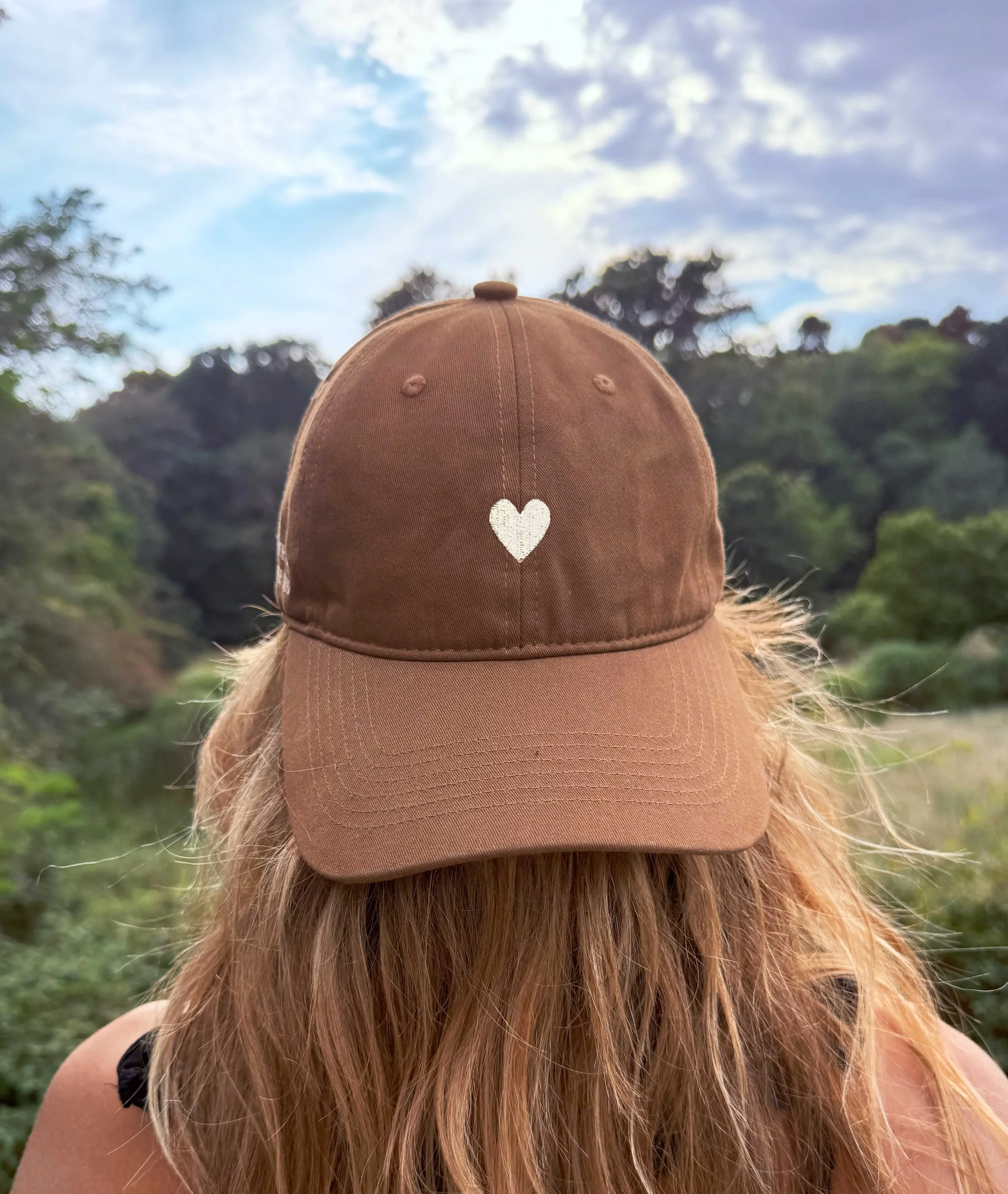 Atticus Poetry 100% cotton  pigment dyed dad hat in the color mocha with a white embroidered heart and the words "Love her, but leave her wild"