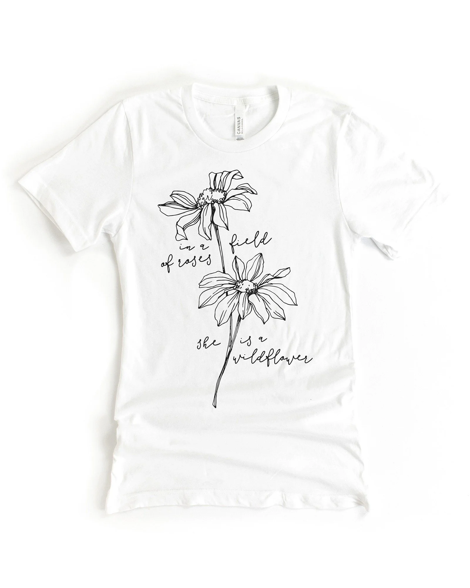 Alley & Rae short sleeved graphic tee in white with the phrase " In a field of Roses She is a Wild Flower."