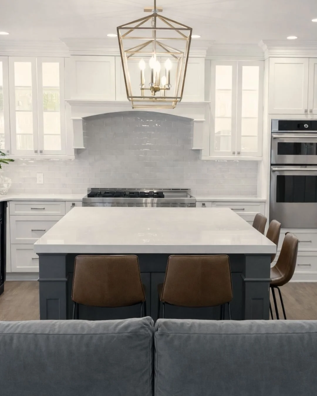 Thinking back to this open floorplan transformation. We love how we tied the two spaces together by using a sophisticated palette of neutrals. The soft, airy perimeter cabinets were grounded by the bold charcoal island and touches of gold and rich br