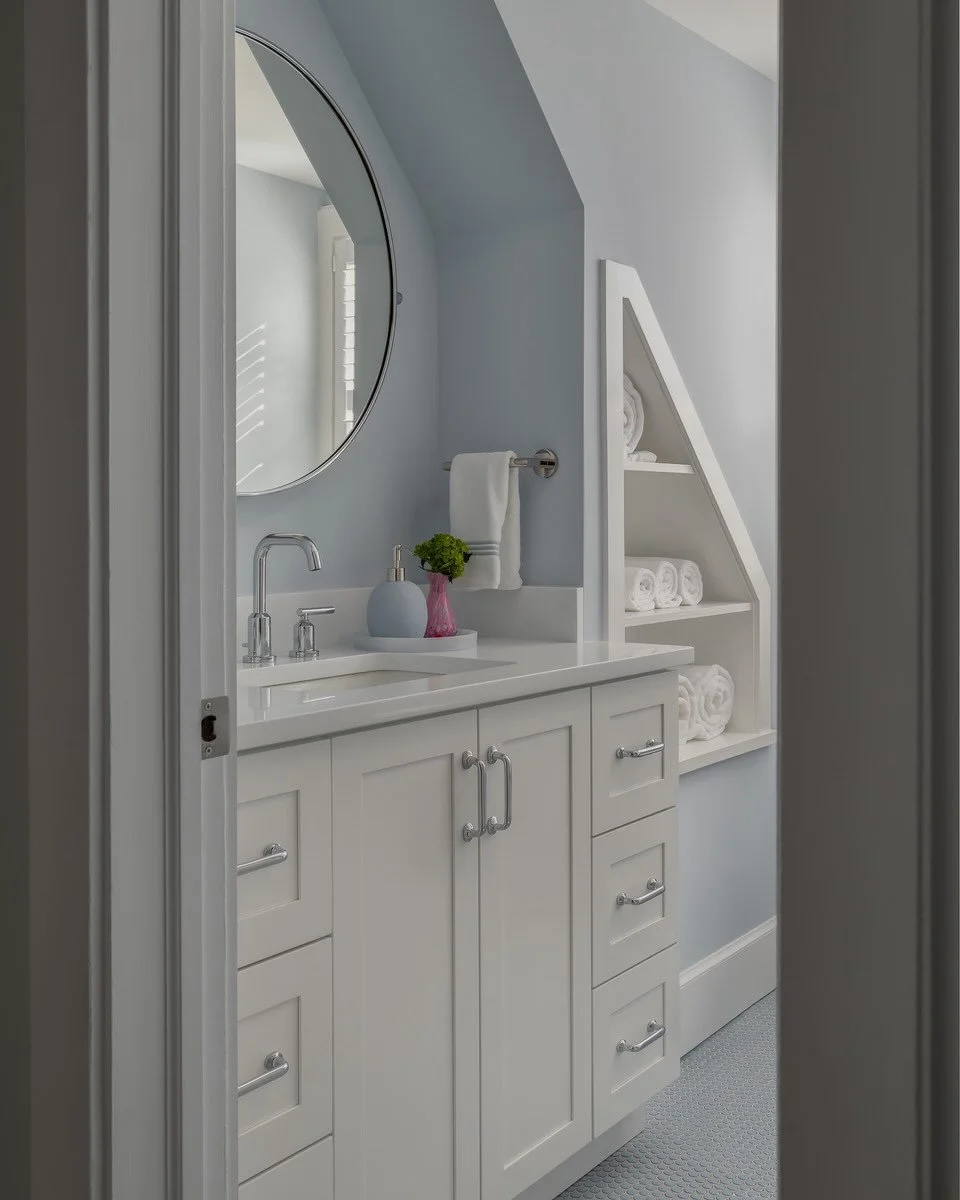 So fresh and so clean! This hall bathroom renovation features a light and airy palette, custom shelving built into the nook beneath the eaves, and blue penny tile that adds a subtle touch of personality. Mornings just got a little brighter.

#Bathroo