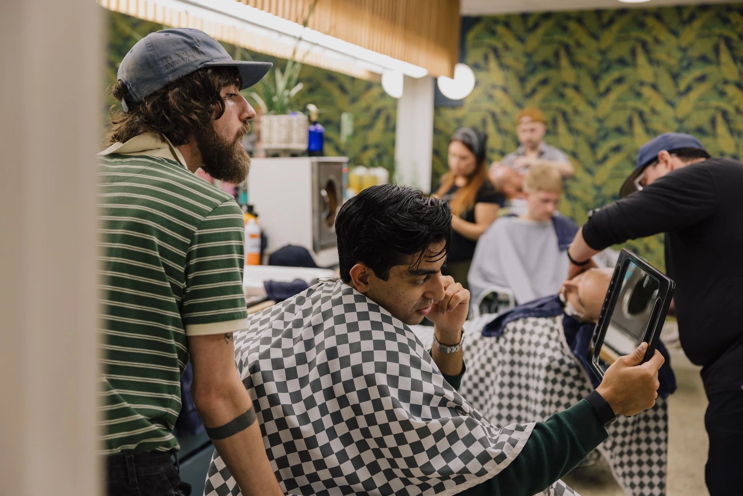 Barber discussing haircut details with a client at Little Barber, a friendly Austin barbershop environment.