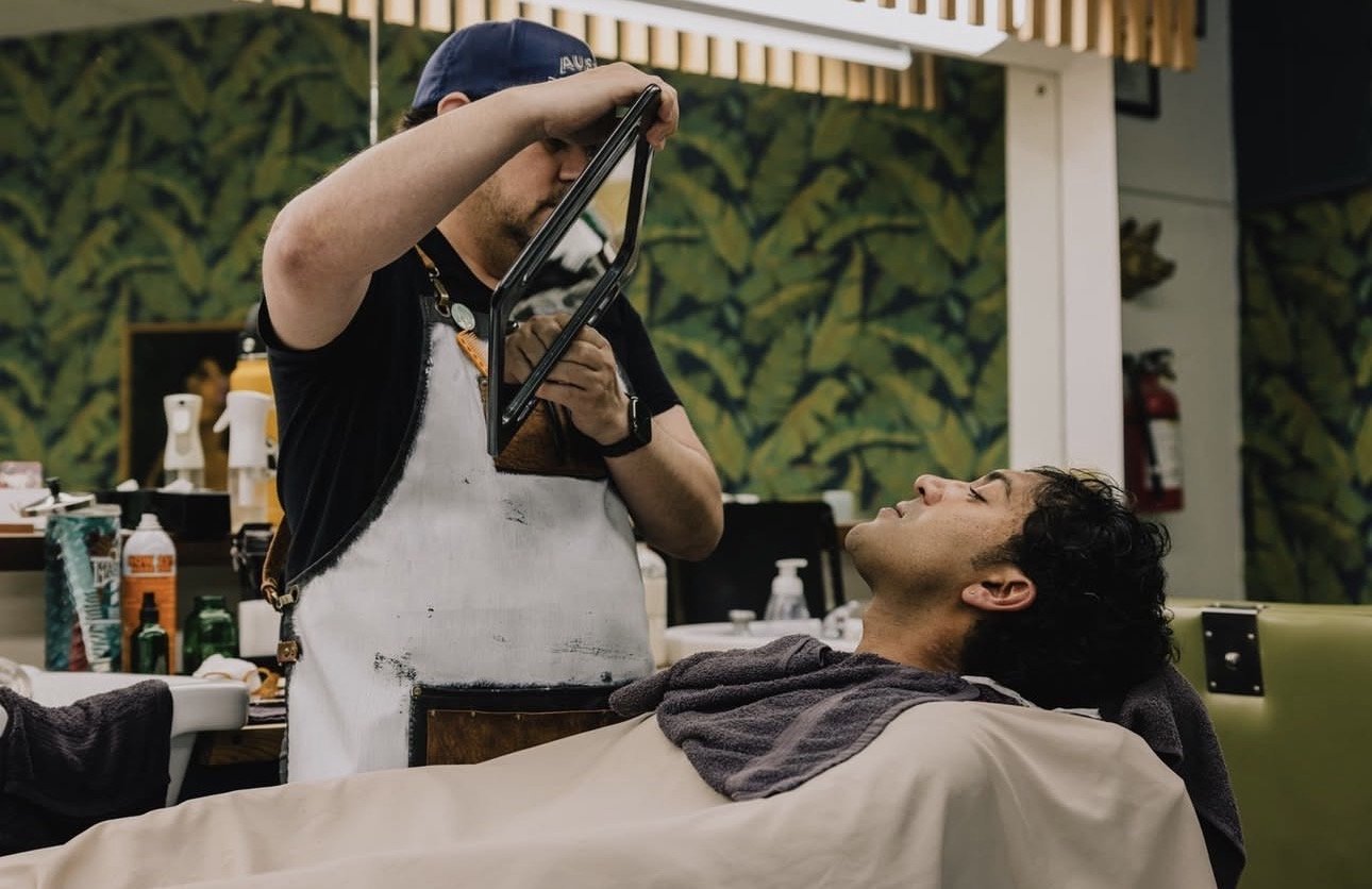 Barber performing a traditional hot towel shave at Little Barber in Austin, showcasing classic barber services.