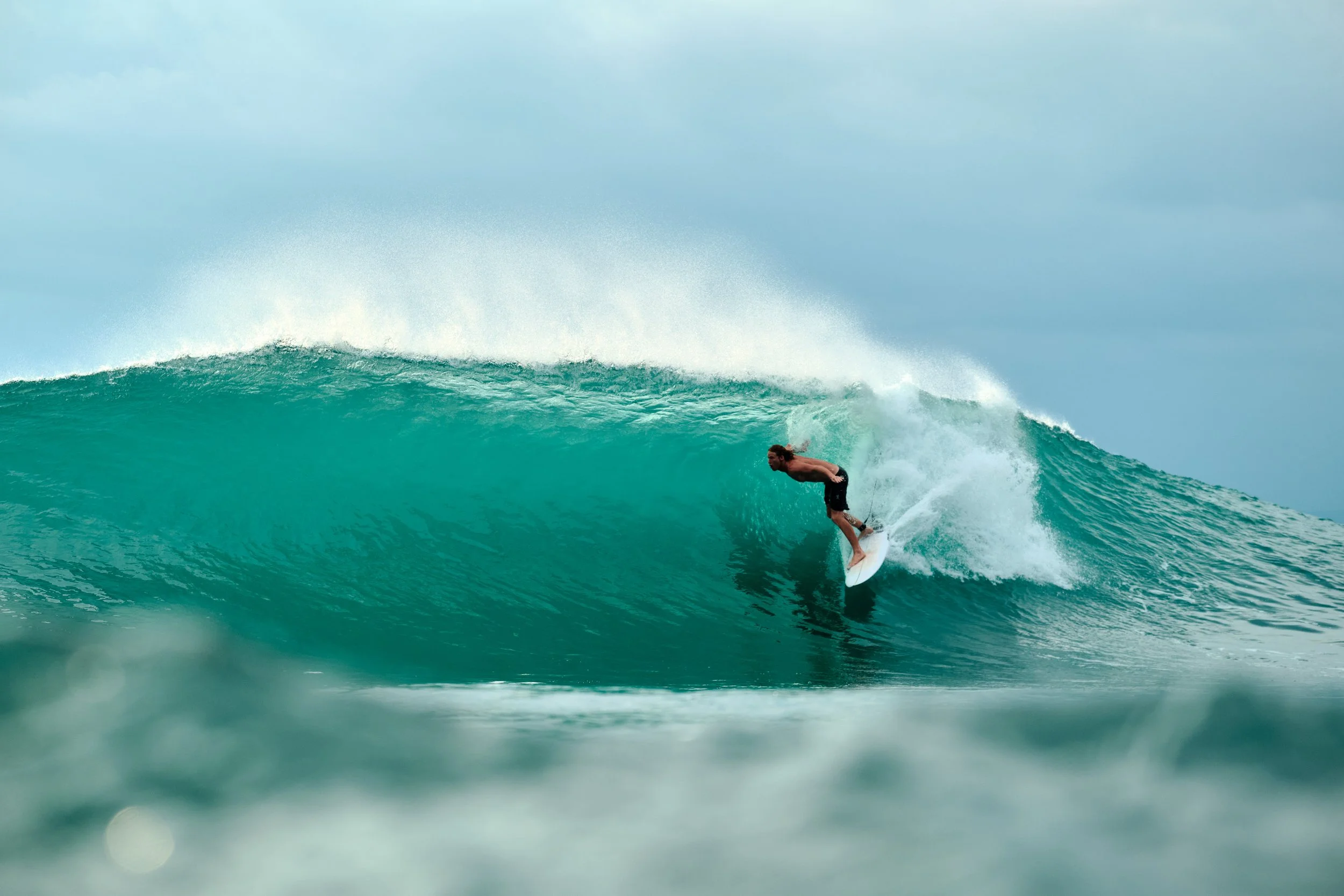 Surfer on a long left wave at Mandiri Beach, Krui, South Sumatra