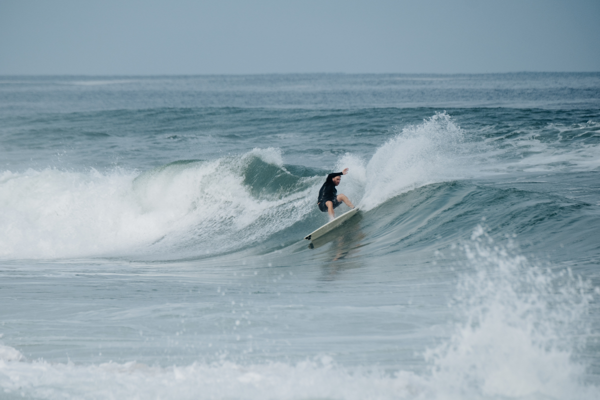 A person surfing on a wave in the ocean during daytime.