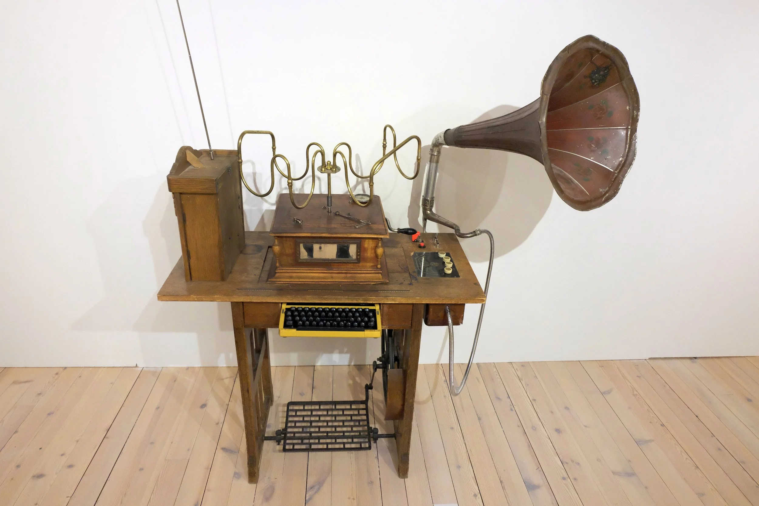 Tidsmaskin. 2025. 190x150x140cm. Interaktiv, kinetisk skulptur. Materialer: antikk symaskin, gramofonspiller, urverk, skrivemaskin, radio, knapper m.m