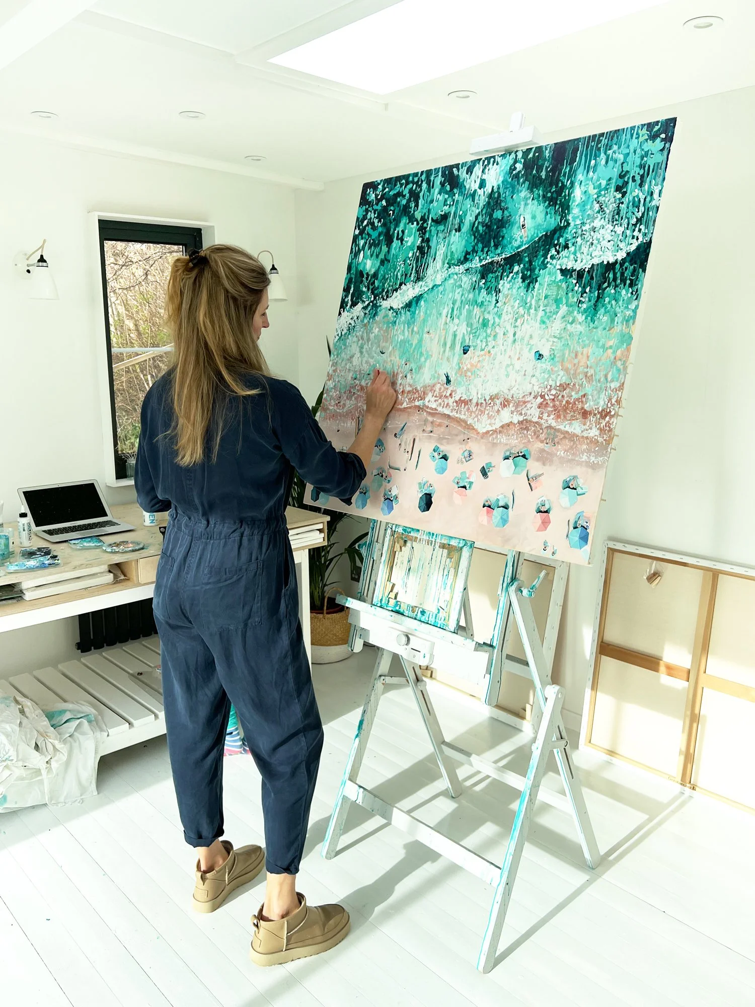 Large original aerial acrylic painting 'Drifting Shores' by Lucy Young. Features the white sands and turquoise waves of Porthcurno Beach, Cornwall, with surfers and bodyboarders.