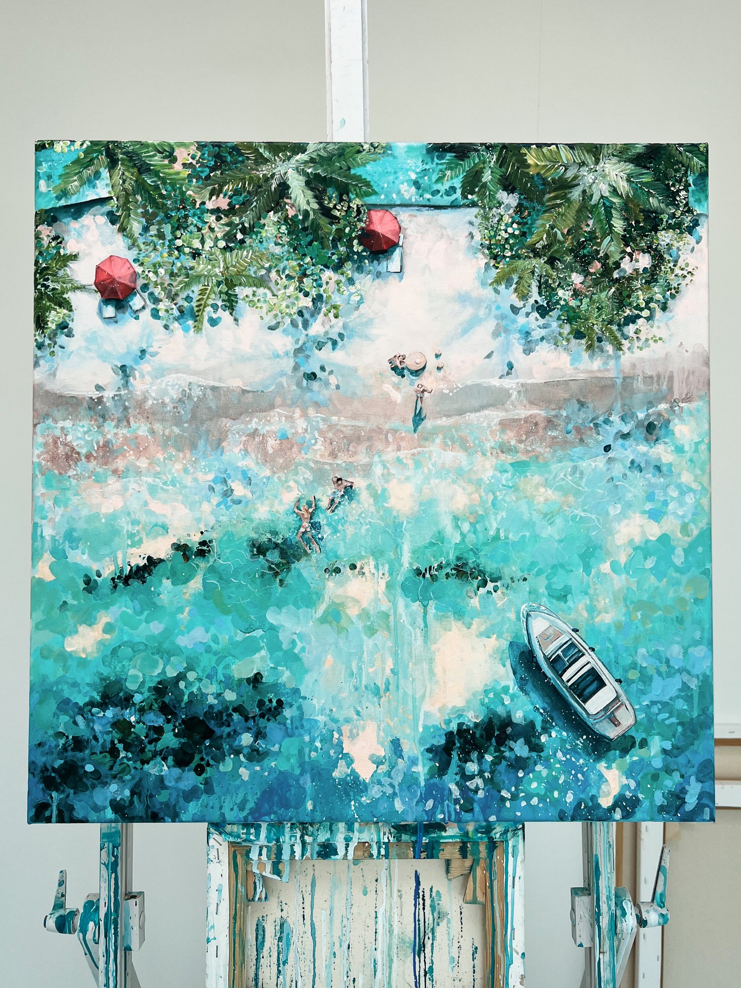 Original aerial acrylic painting 'Pure Paradise' by Lucy Young. Features a luxury Maldives resort beach with white sand, palm trees, a family on the shore, and a bobbing boat in turquoise water.