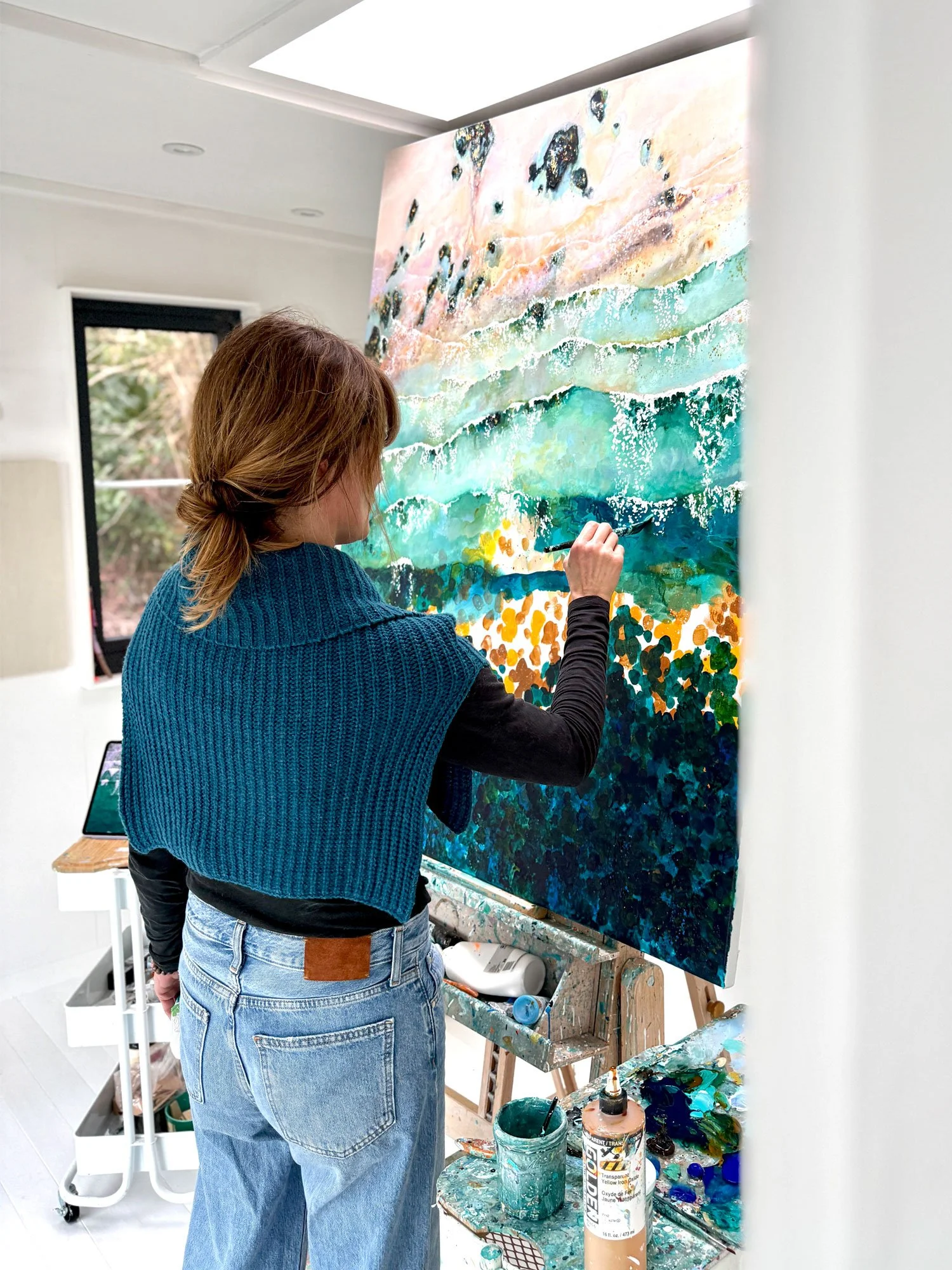 Lucy Young creating the original painting of, 'Graceful Gwithian' in her studio by the sea