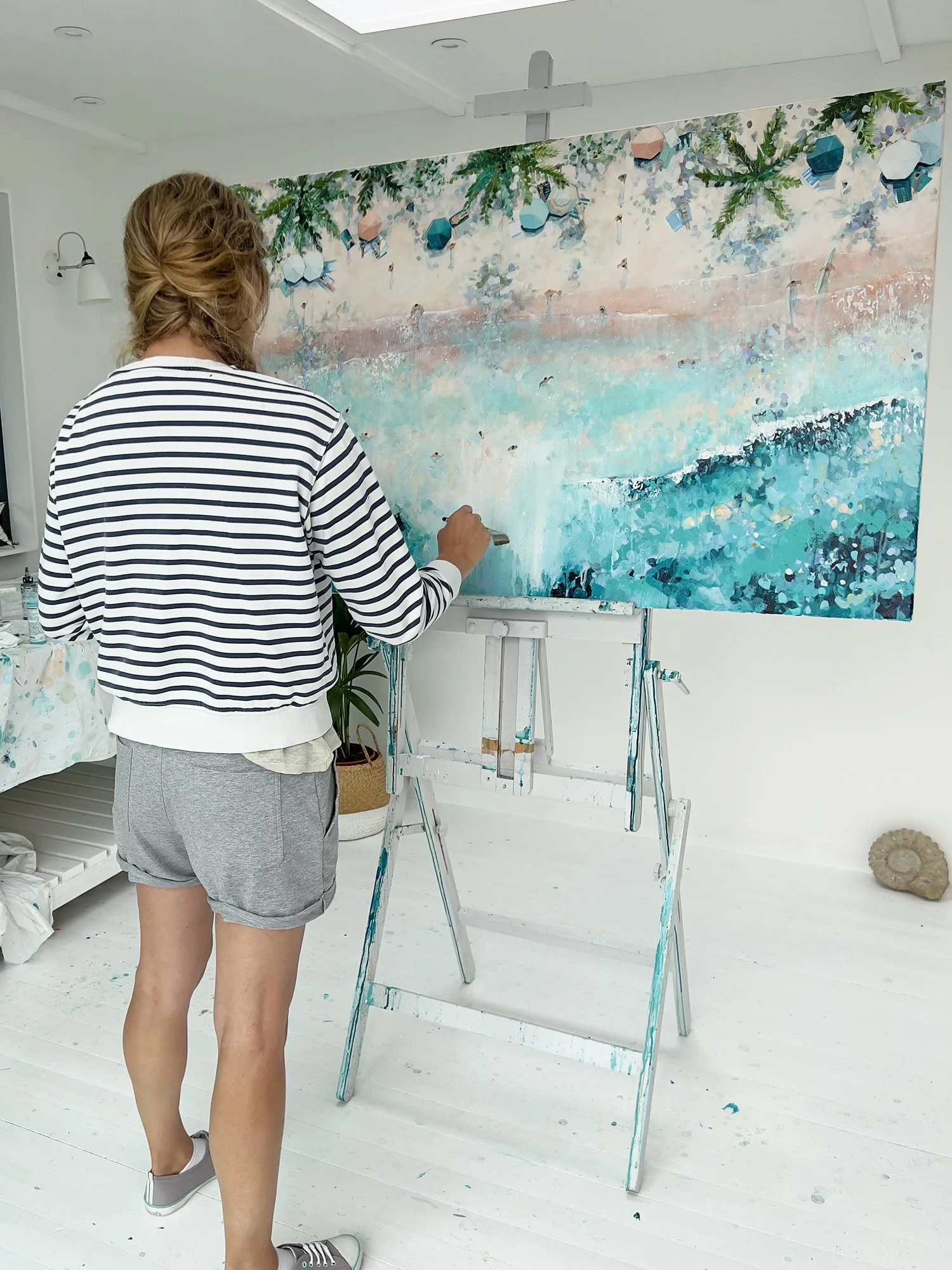 Original aerial acrylic painting 'Palm Light' by Lucy Young. Features a Maldives beach with sun loungers sitting in clear turquoise water under towering palm trees.