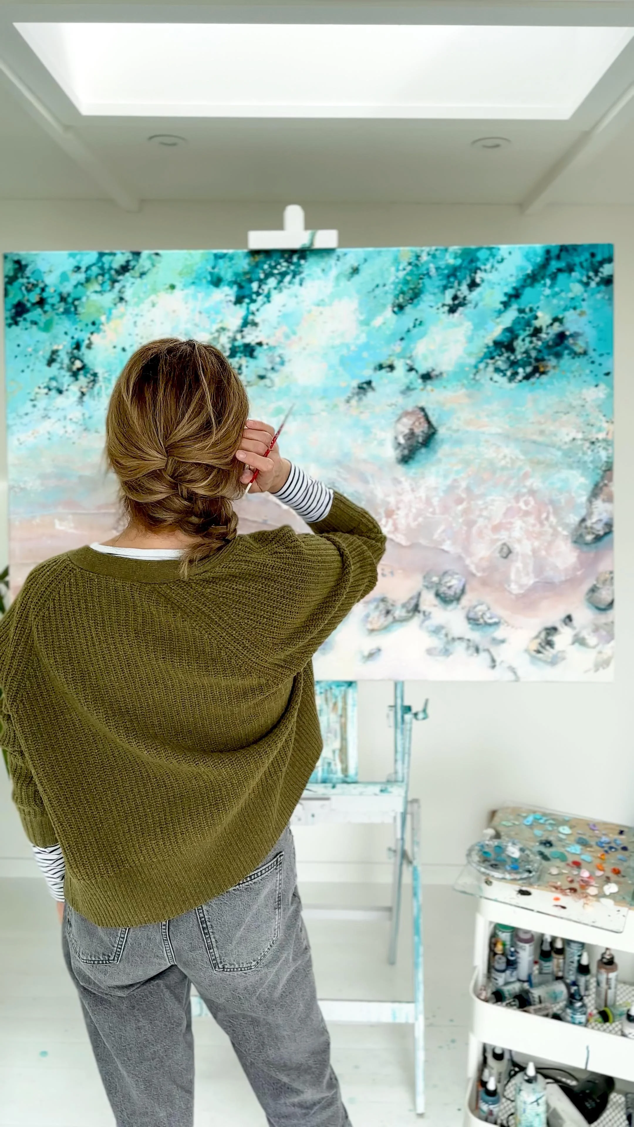 Large original aerial acrylic painting 'Mattiscombe Sands' by Lucy Young. A pastel-toned South Devon beach scene with a sweeping tide line, rocks, and clear water.