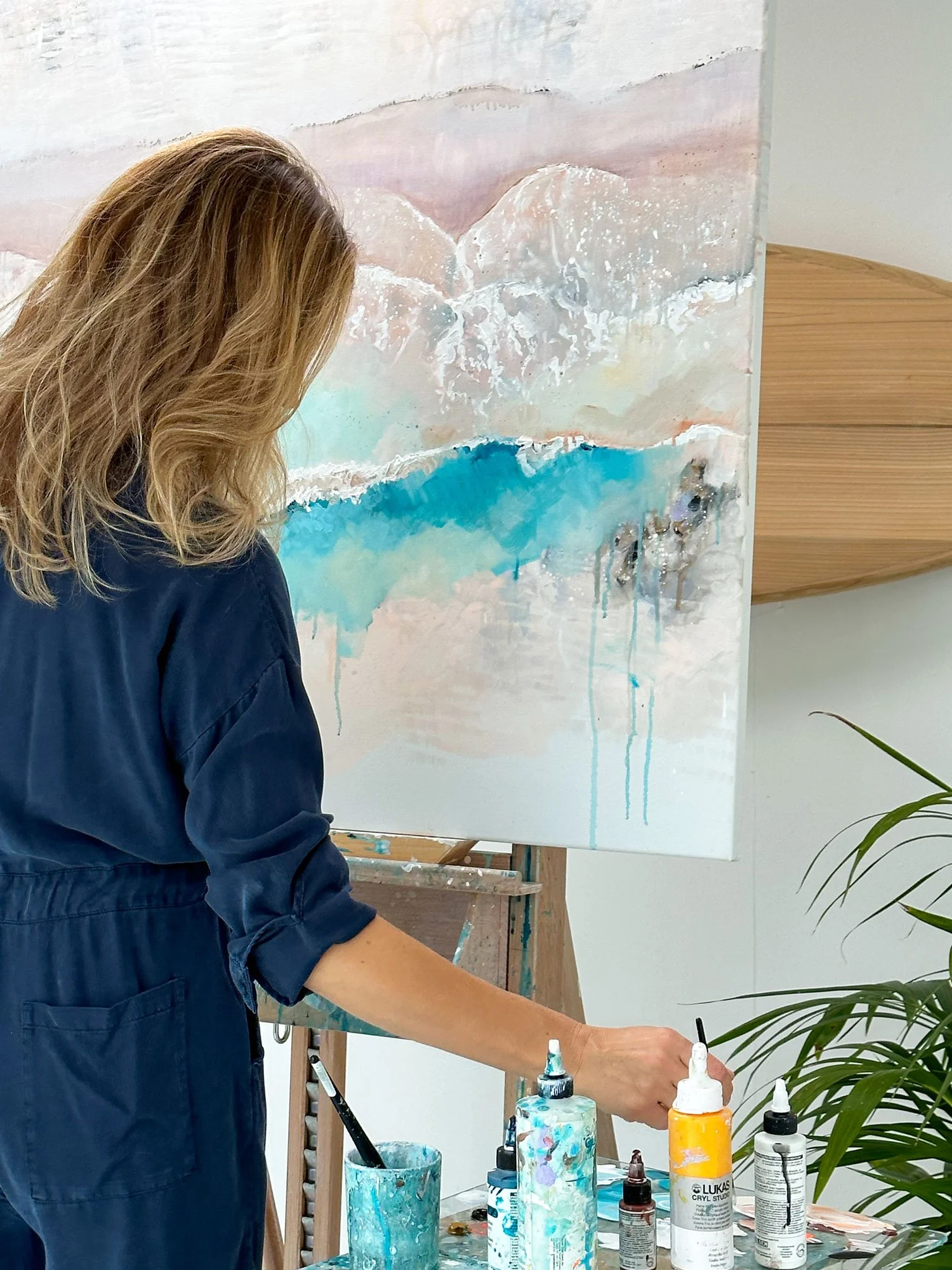 Professional British artist Lucy Young painting a contemporary aerial seascape in her studio.