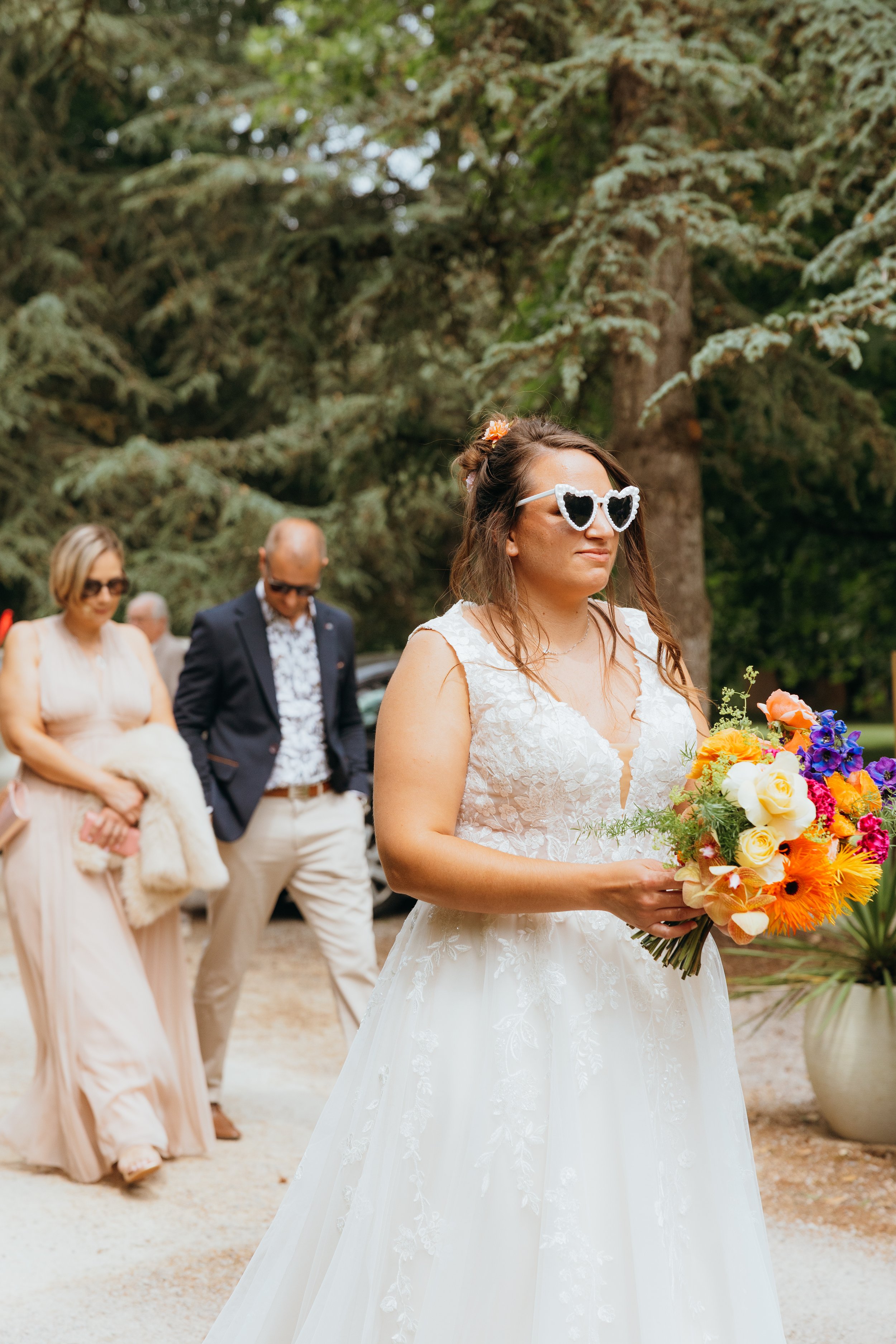 Mariée lunettes coeur avec bouquet de marié aux tons vifs, réalisés par Marine Pineau