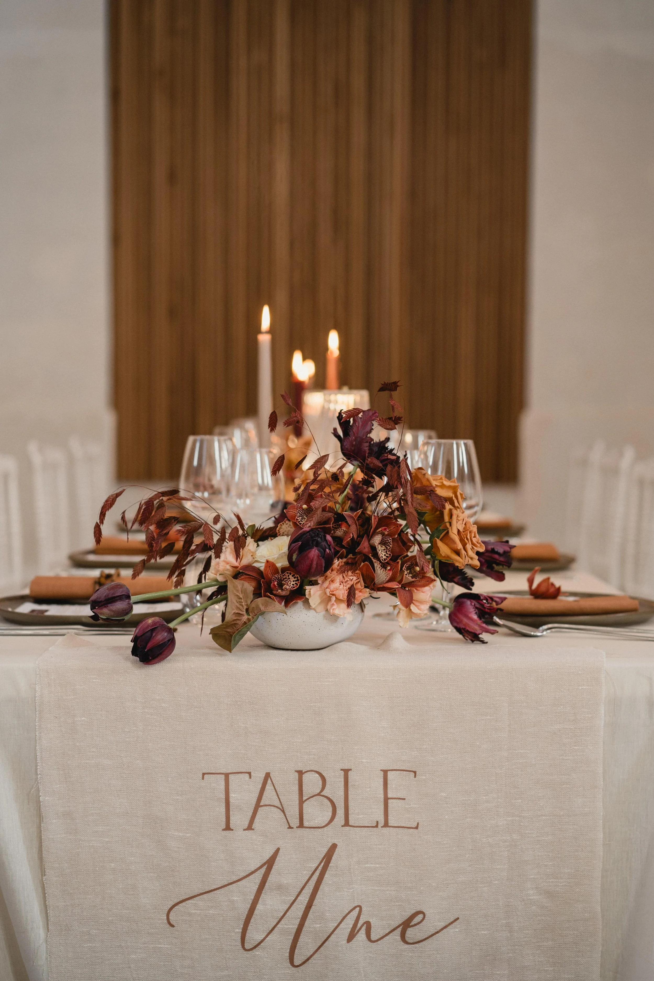 Décoration florale pour table de mariage - tendance moka - Nude – Installation d’un centre de table, disposé sur une longue table pour une réception dans une abbaye région nantaise. Décor floral signé Marine Pineau, La Fille aux Fleurs.