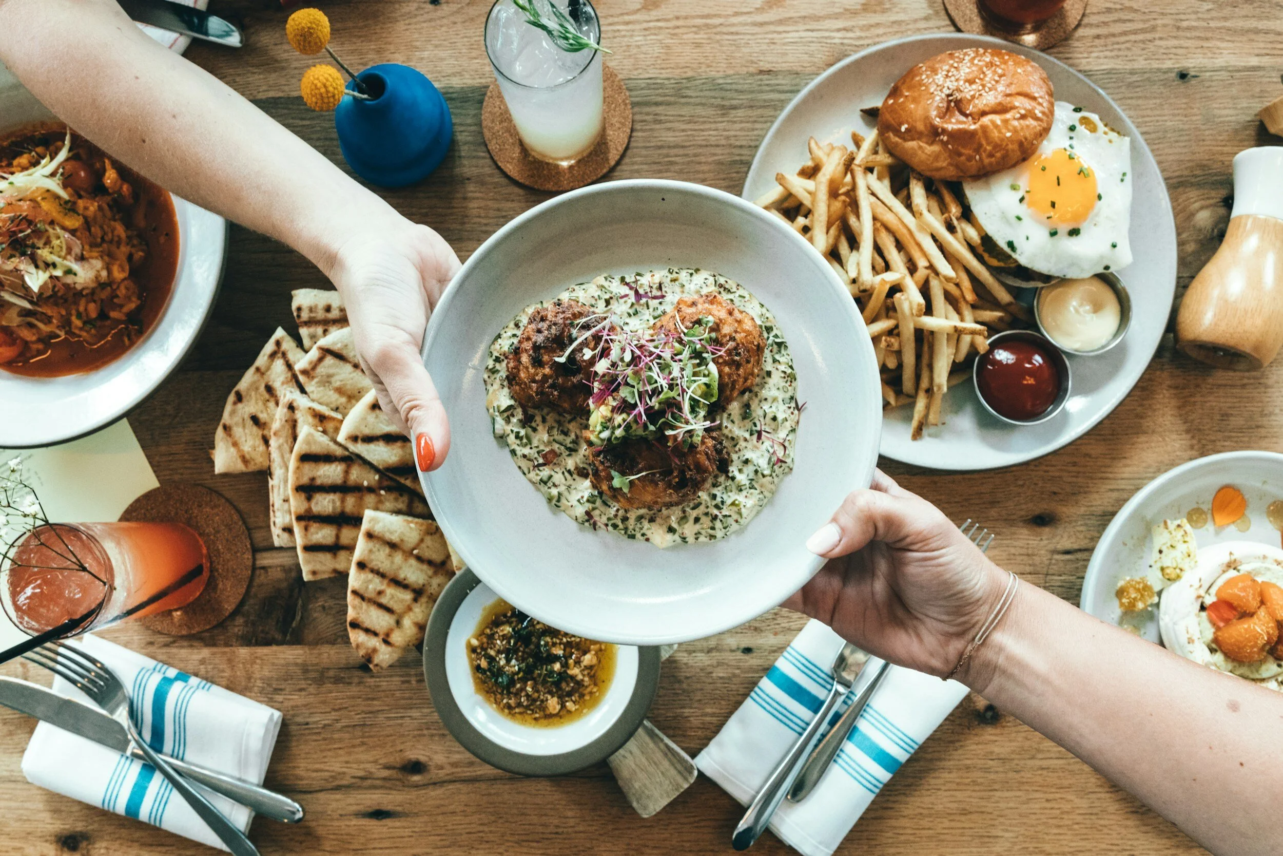 hands passing a dish at a restaurant