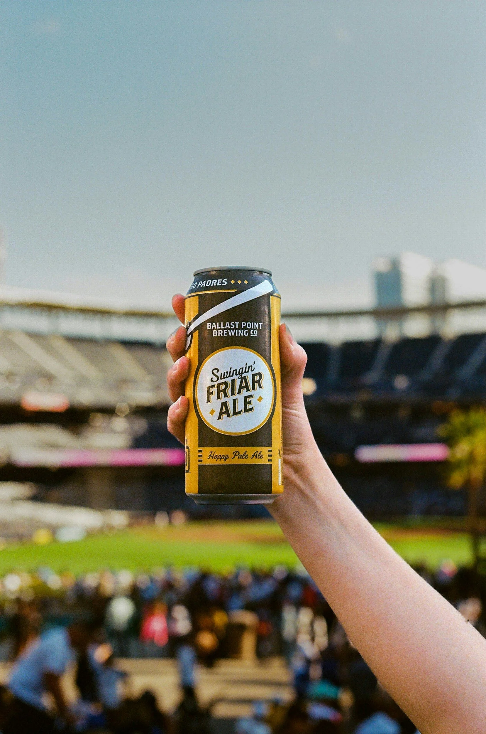 hand holding a beer can at a sporting event