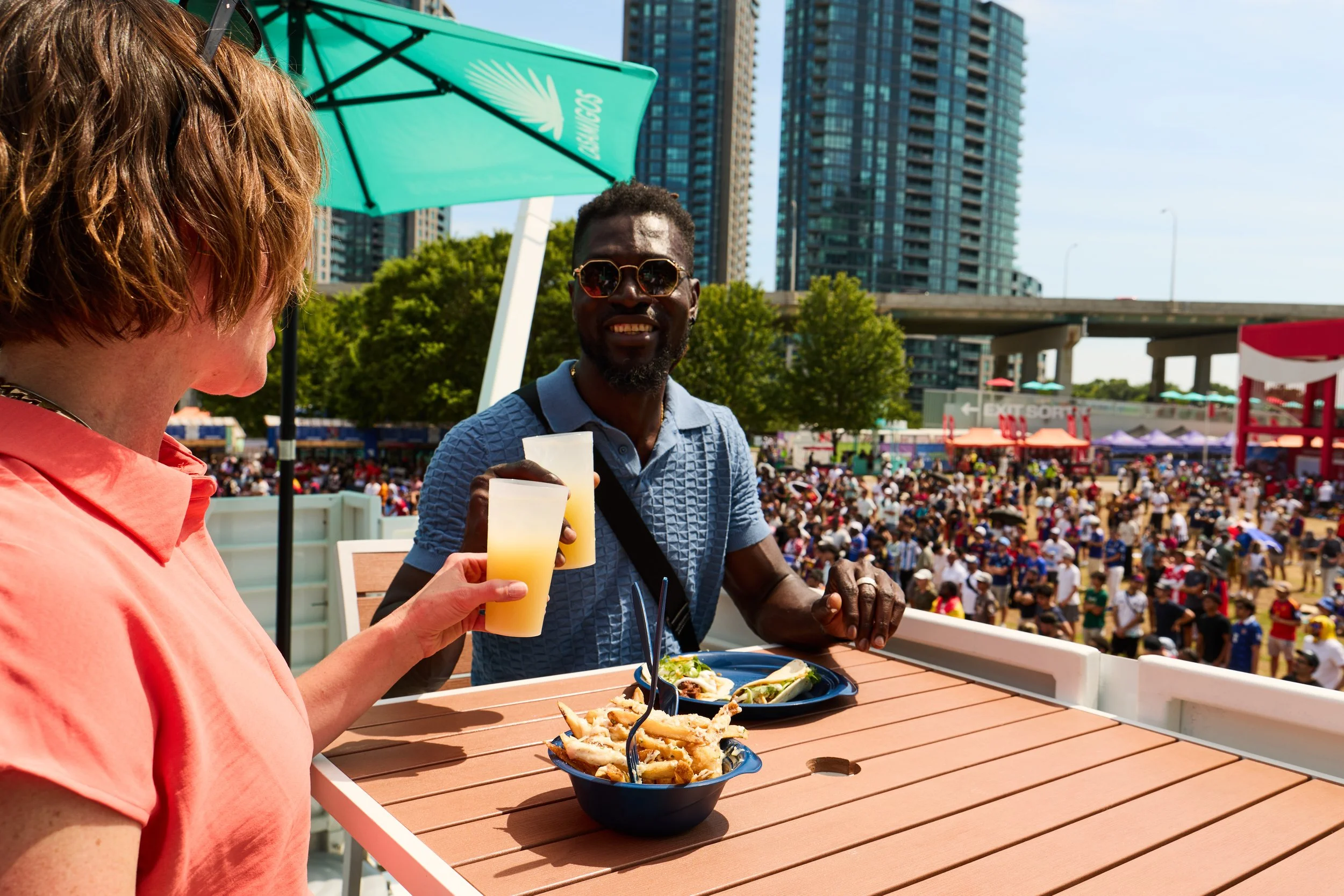 two people at a FIFA Fan Fest, eating out of reusable dishes