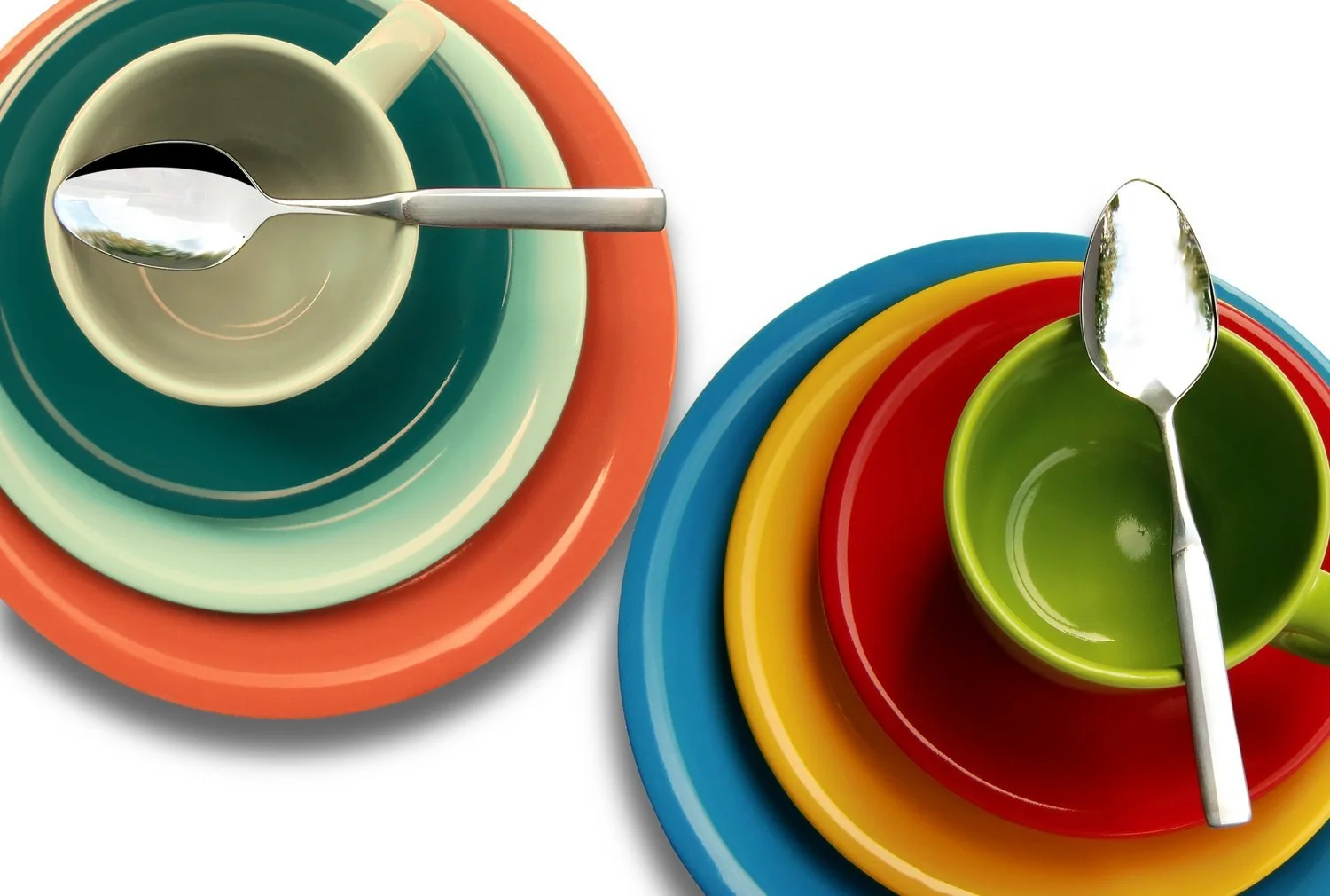 Colorful stacked plates and bowls with spoons on a white background.