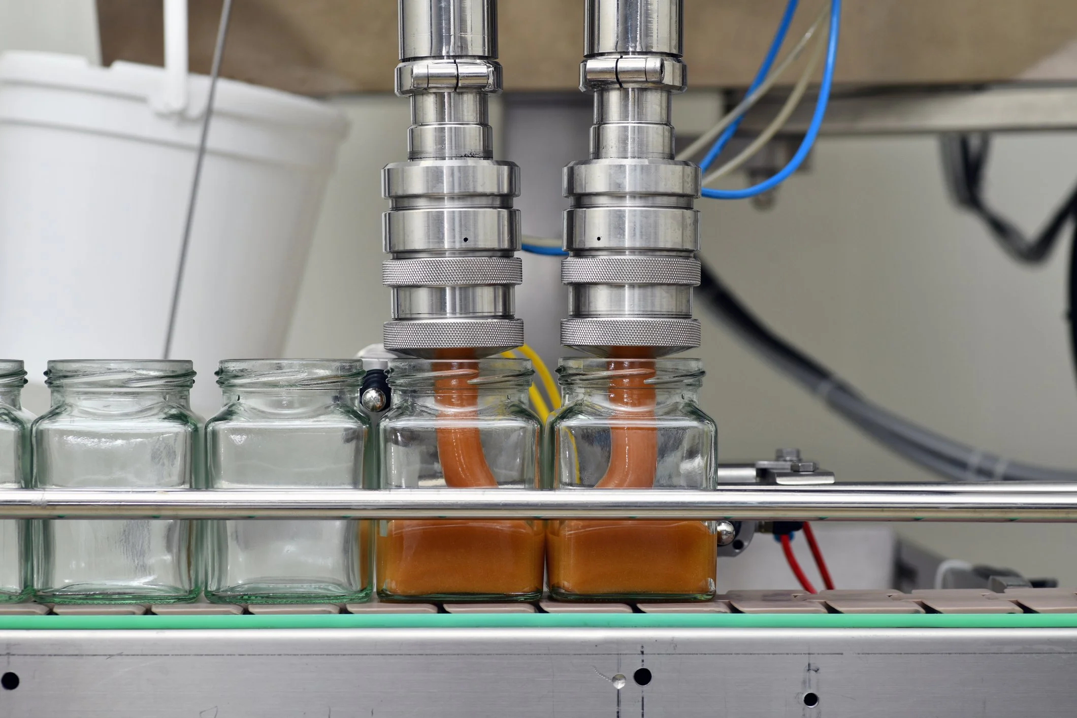 honey jars being refilled in a commercial factory