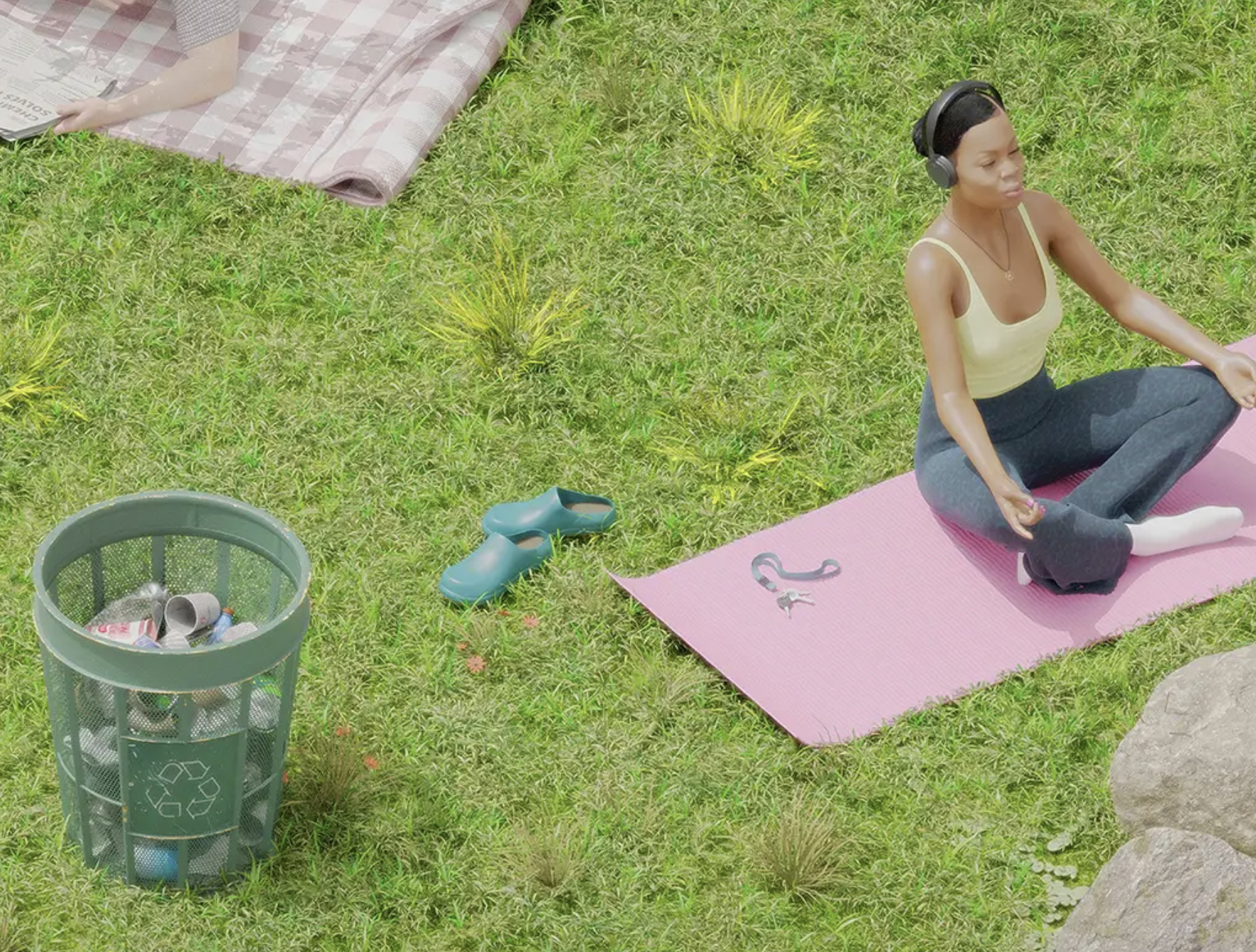 woman doing yoga in a park next to a recycling barrel