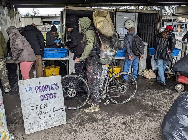 sign saying the People's Depot with bottle collectors standing in front of it