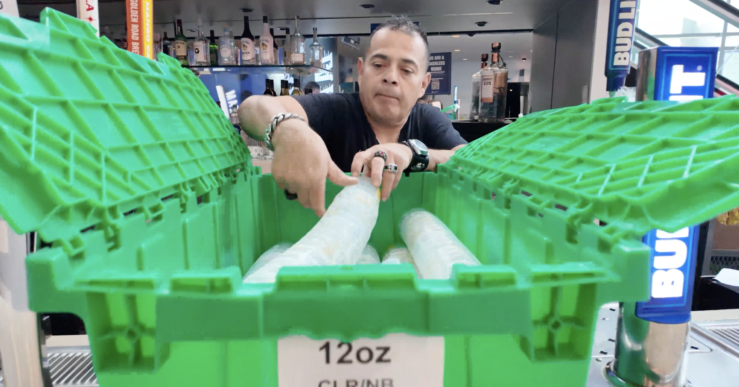man emptying clean reusable cups out of a crate