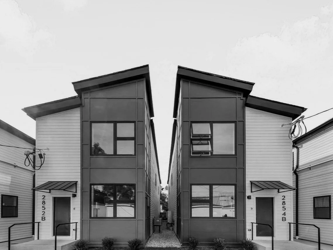 Modern duplex buildings with slanted roofs and large windows