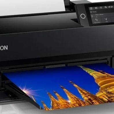 A black Epson printer with a printed photo emerging from the front tray.