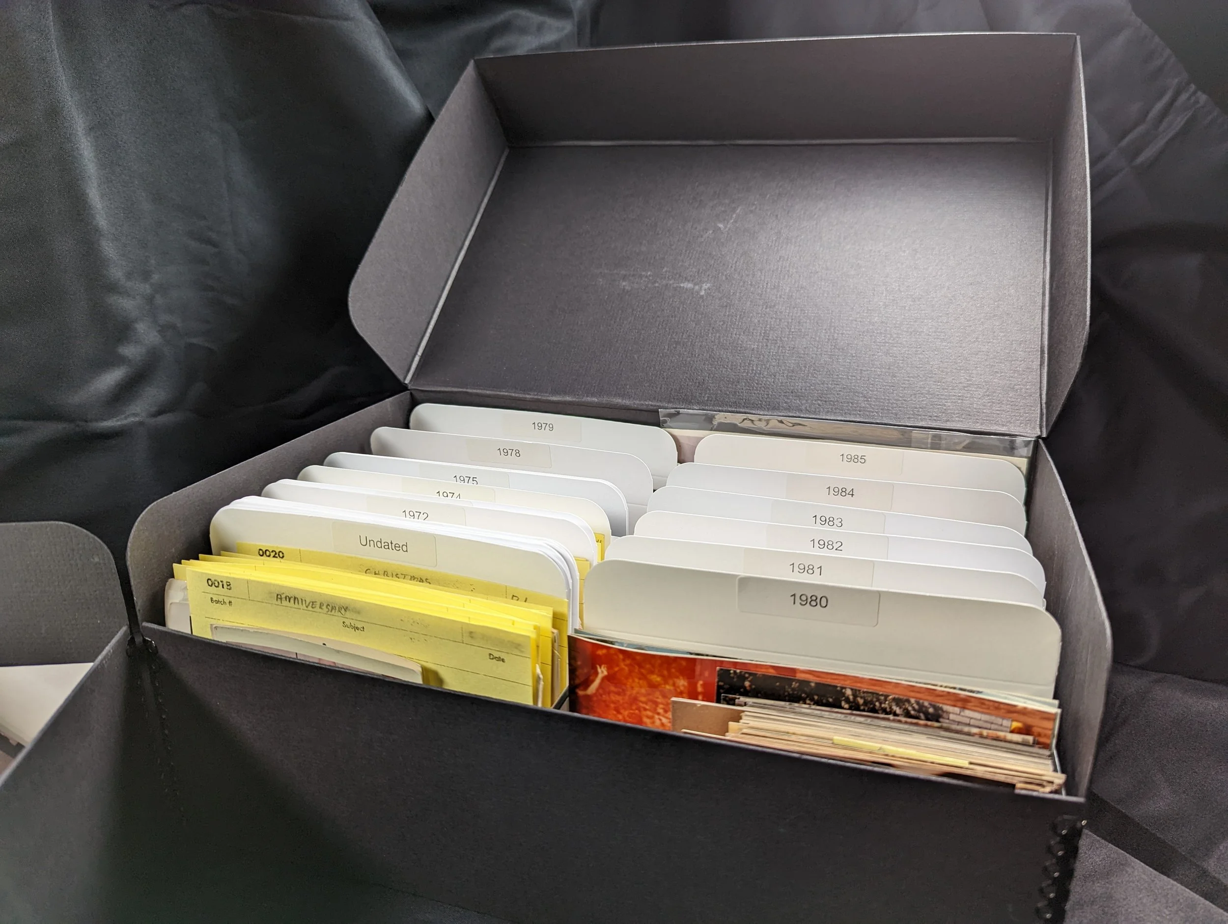 Photos organized with dividers in a box, separated by years