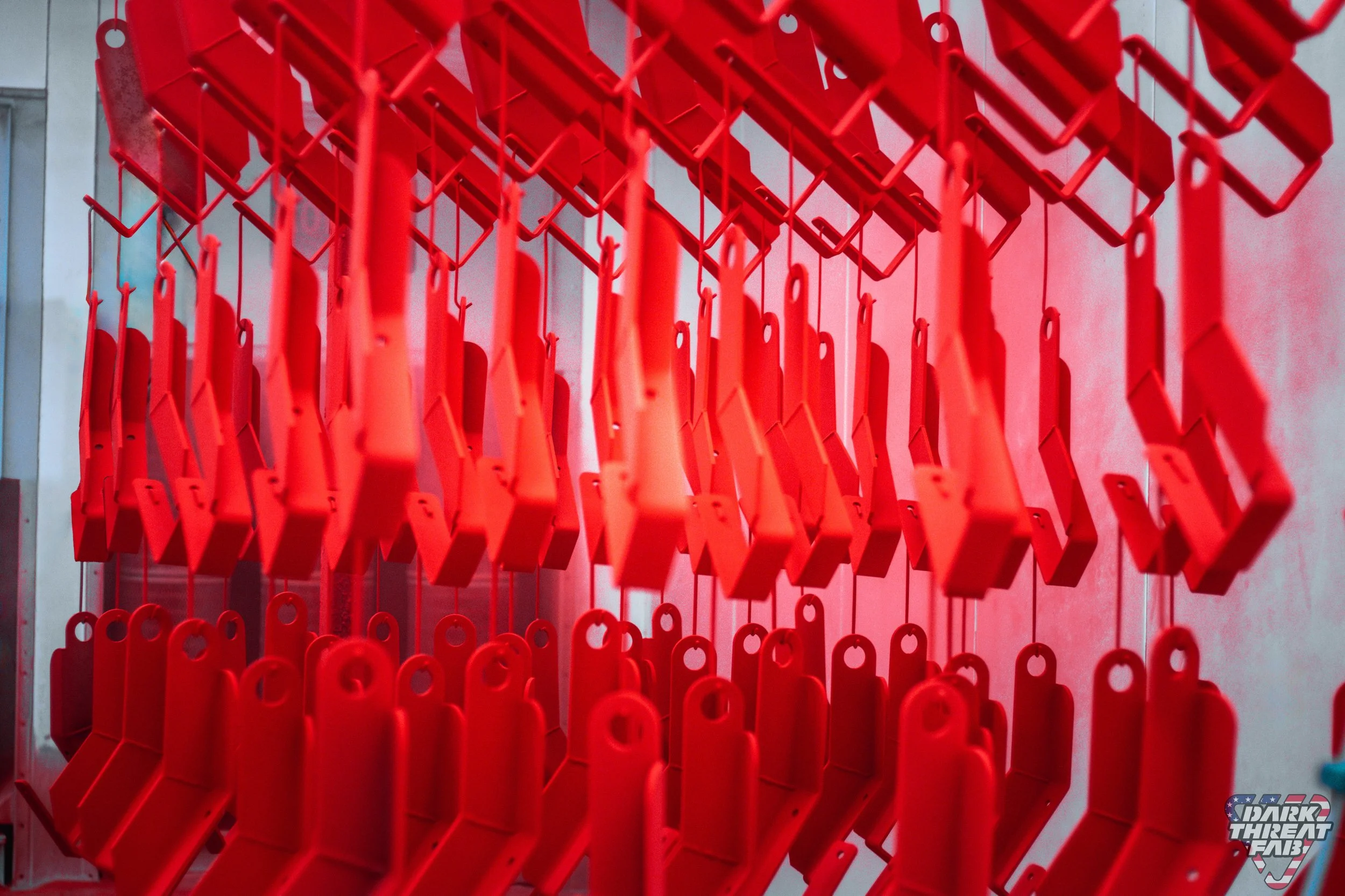 Multiple red plastic seat covers or masks hanging in a row, likely for protection or display.