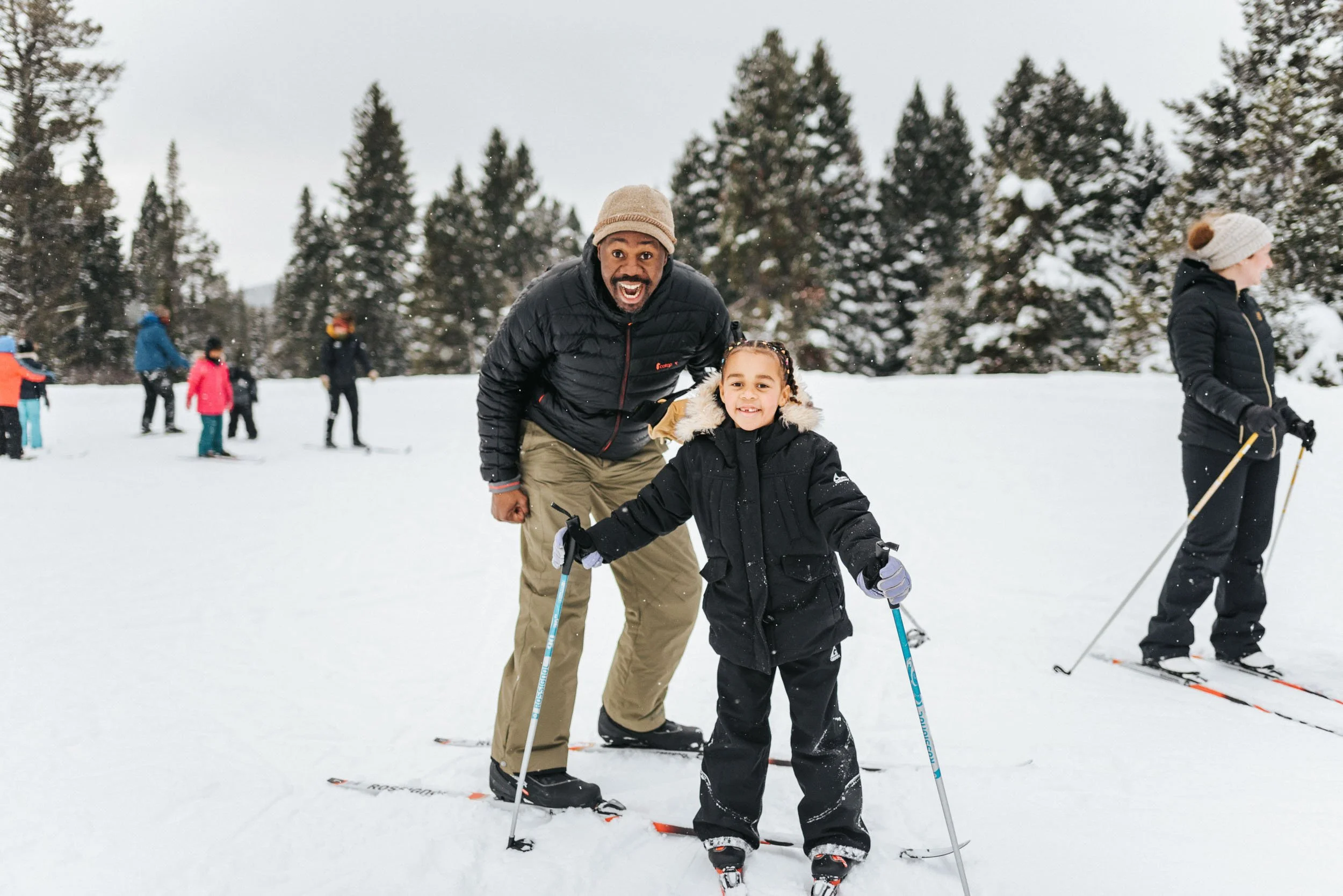 A father and daughter are excited to be on the snow and ready for cross-country skiing