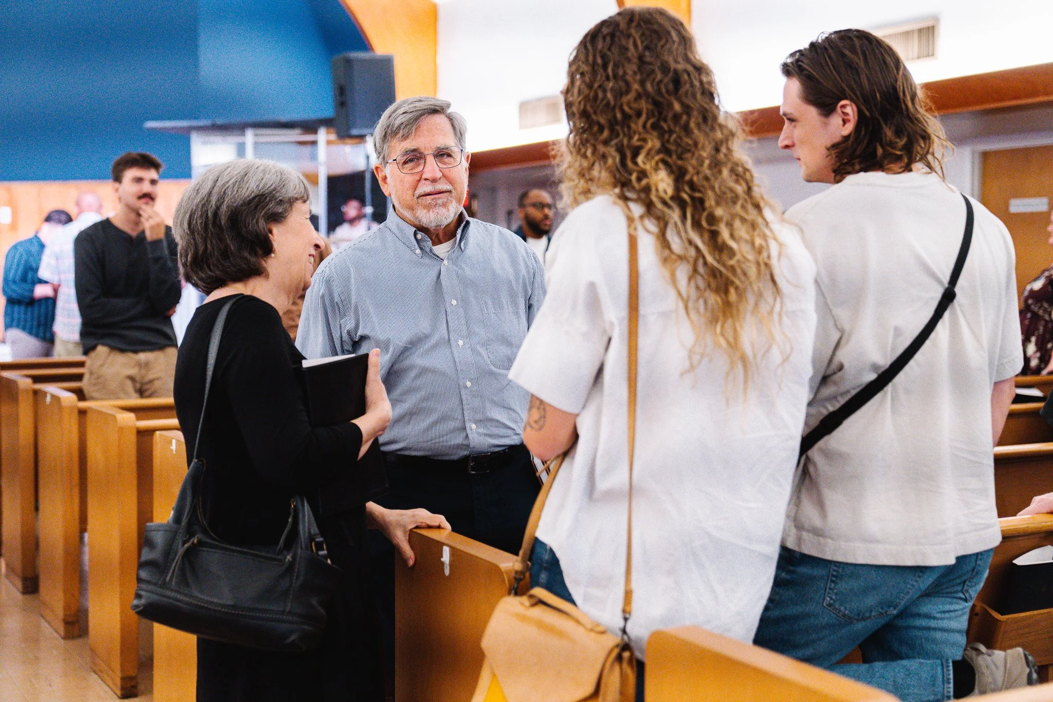 People older couple speaking to younger couple