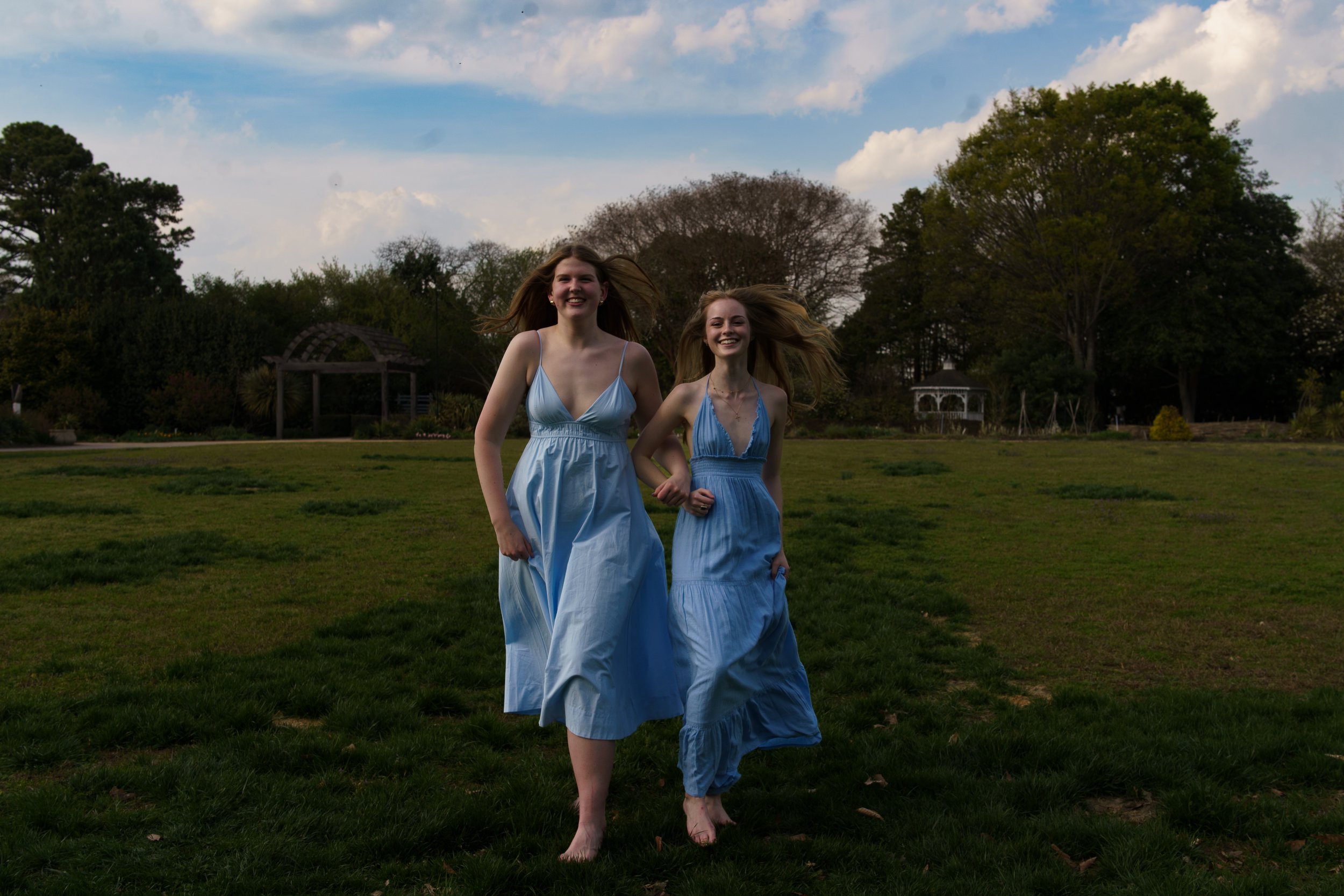 Senior Friends Portrait Sessions available in Raleigh, North Carolina. Two friends running through an open field to celebrate their friendship and senior year.