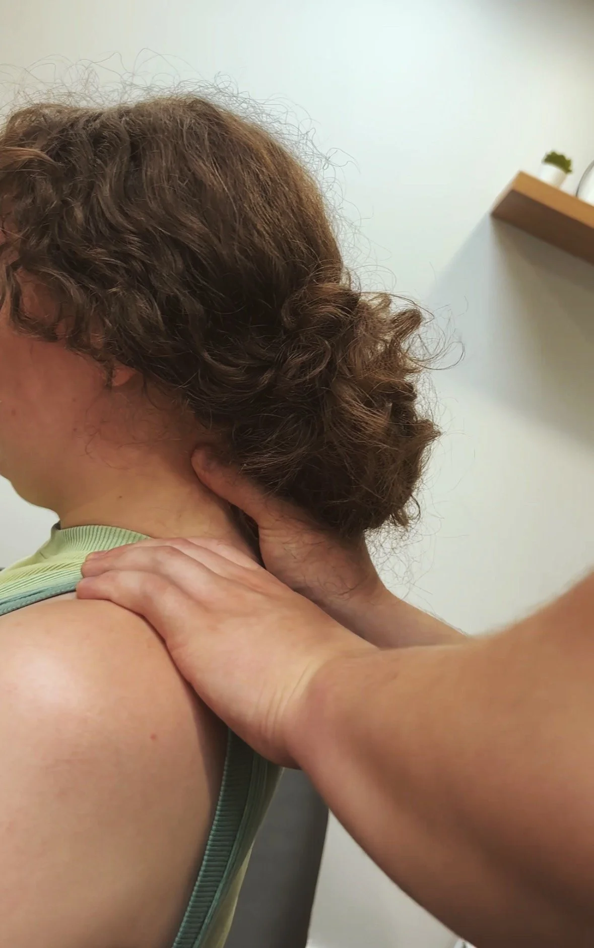 A person receiving a neck massage from another individual.