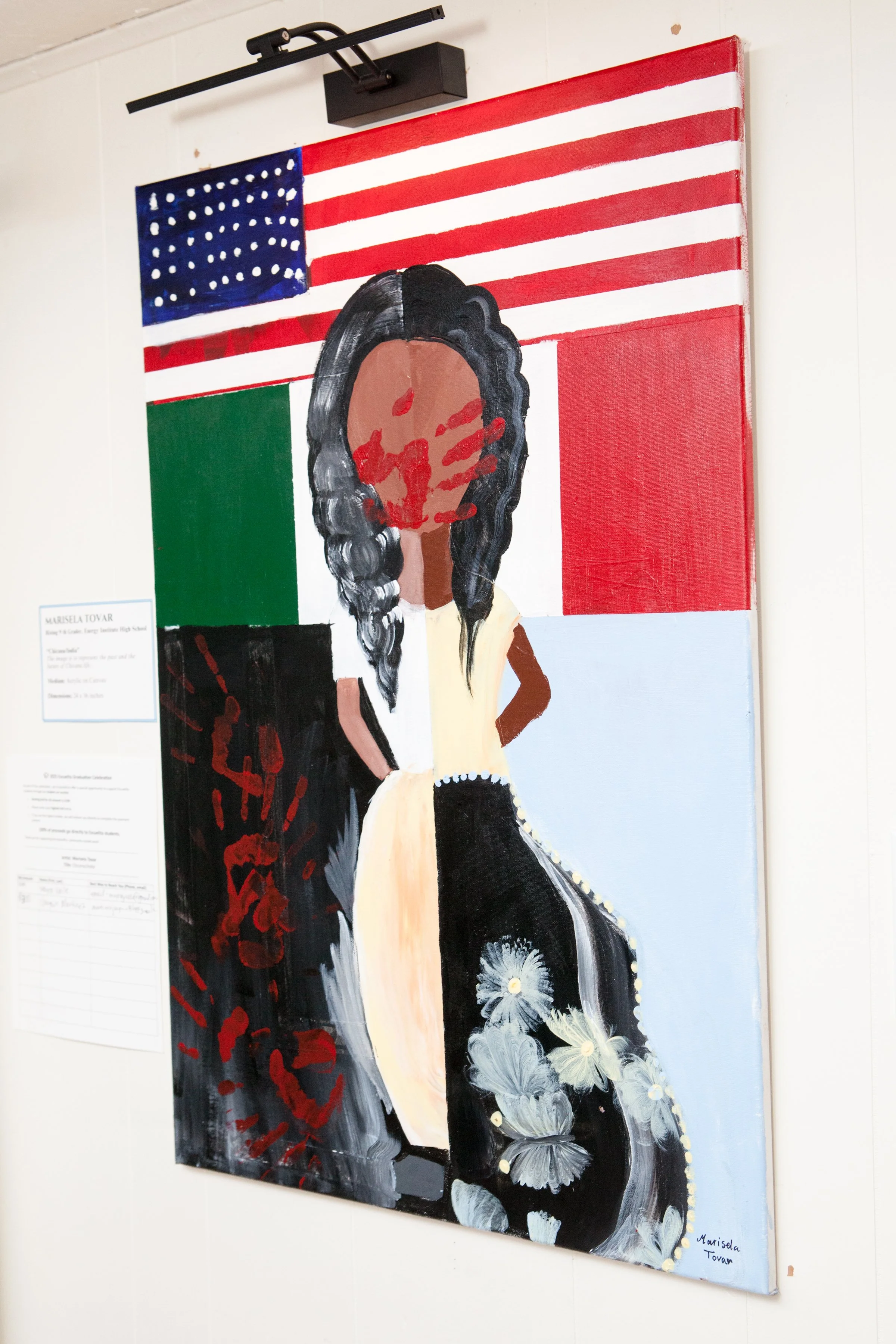 Painting of a woman with long black hair, wearing a dress with white floral patterns, set against a background of the American and Mexican flags.
