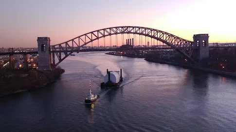 A tug boat approaching the Hell Gate Bridge on the East River, New York.